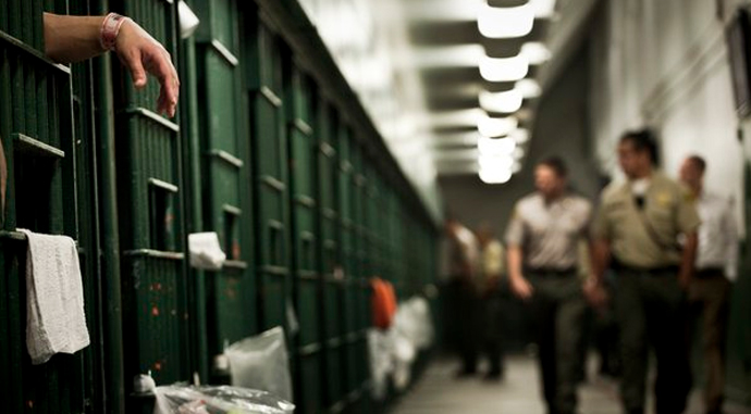 Deputies walk past cells on the 3000 floor of the L.A. County Men's Central Jail. (Credit: Los Angeles Times)