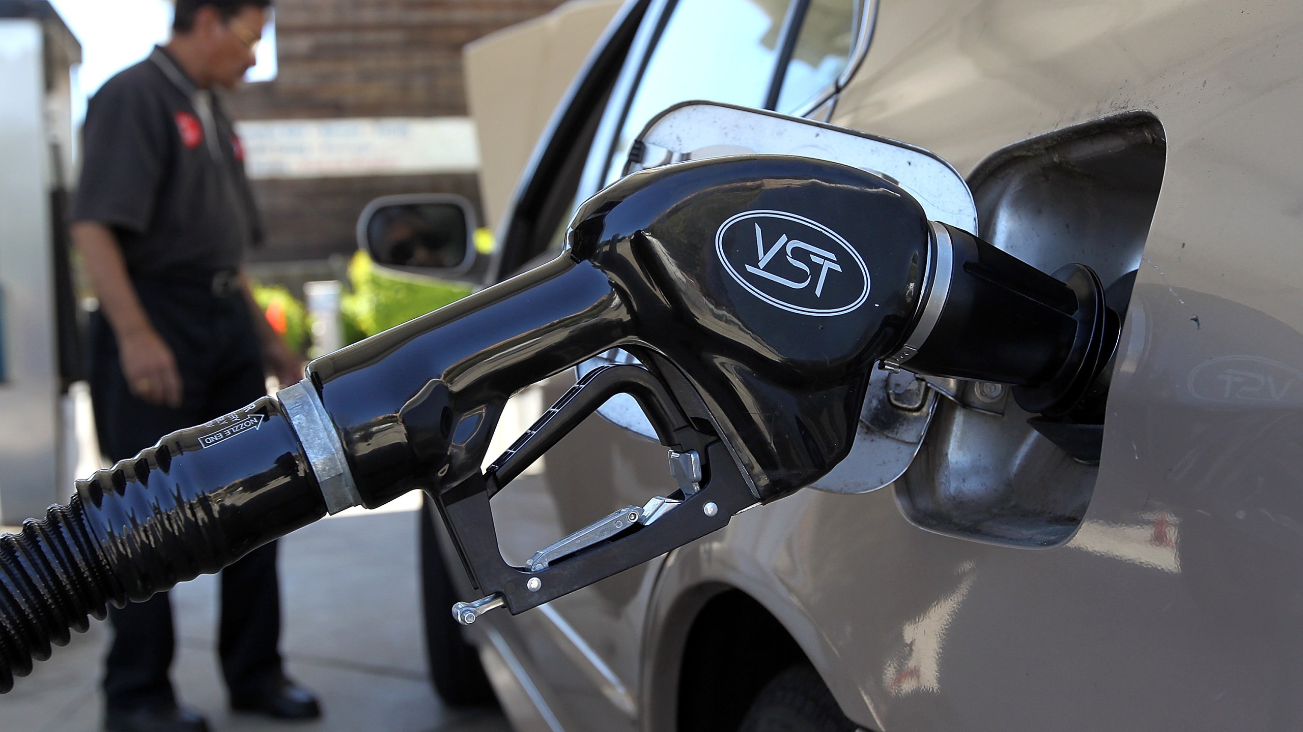 File photo of a gasoline pump resting in the tank of a car.