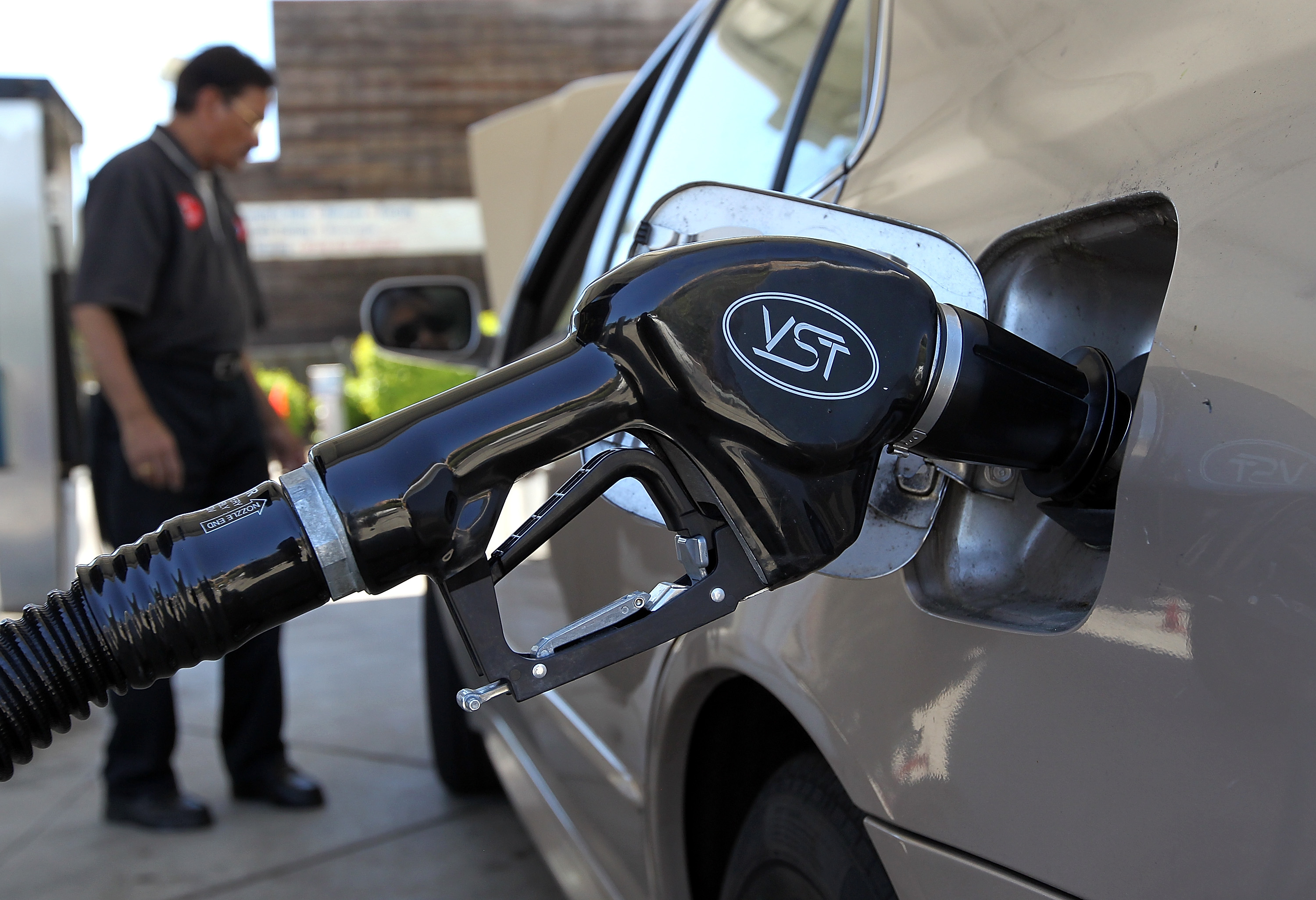 File photo of a gasoline pump resting in the tank of a car.