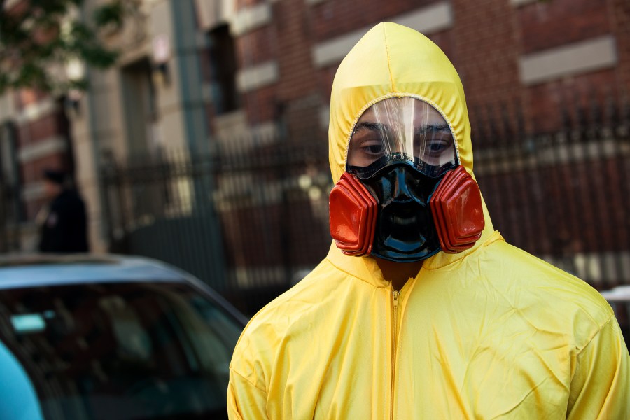 A young man, dressed in a biohazard costume, stands on the corner of 546 West 147th Street on Saturday, Oct. 25, 2014, in New York City. (Credit: Bryan Thomas/Getty Images)