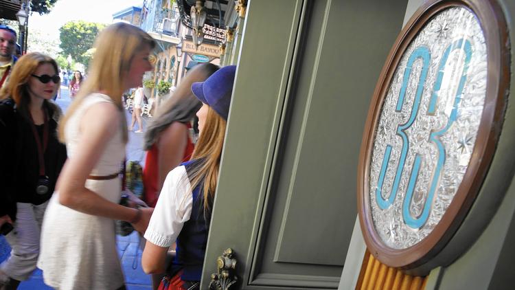 Victoria Dale, guest relations guide, holds open the door to the Club 33 restaurant for visitors on a special paid VIP tour at Disneyland in 2013. (Credit: Don Bartletti/Los Angeles Times)