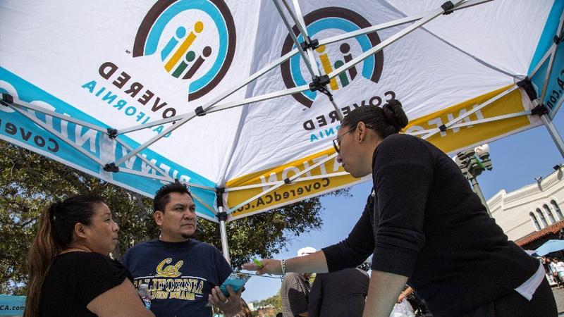 Two Los Angeles residents learn more about Covered California enrollment at a March 2014 event. (Ricardo DeAratanha / Los Angeles Times)