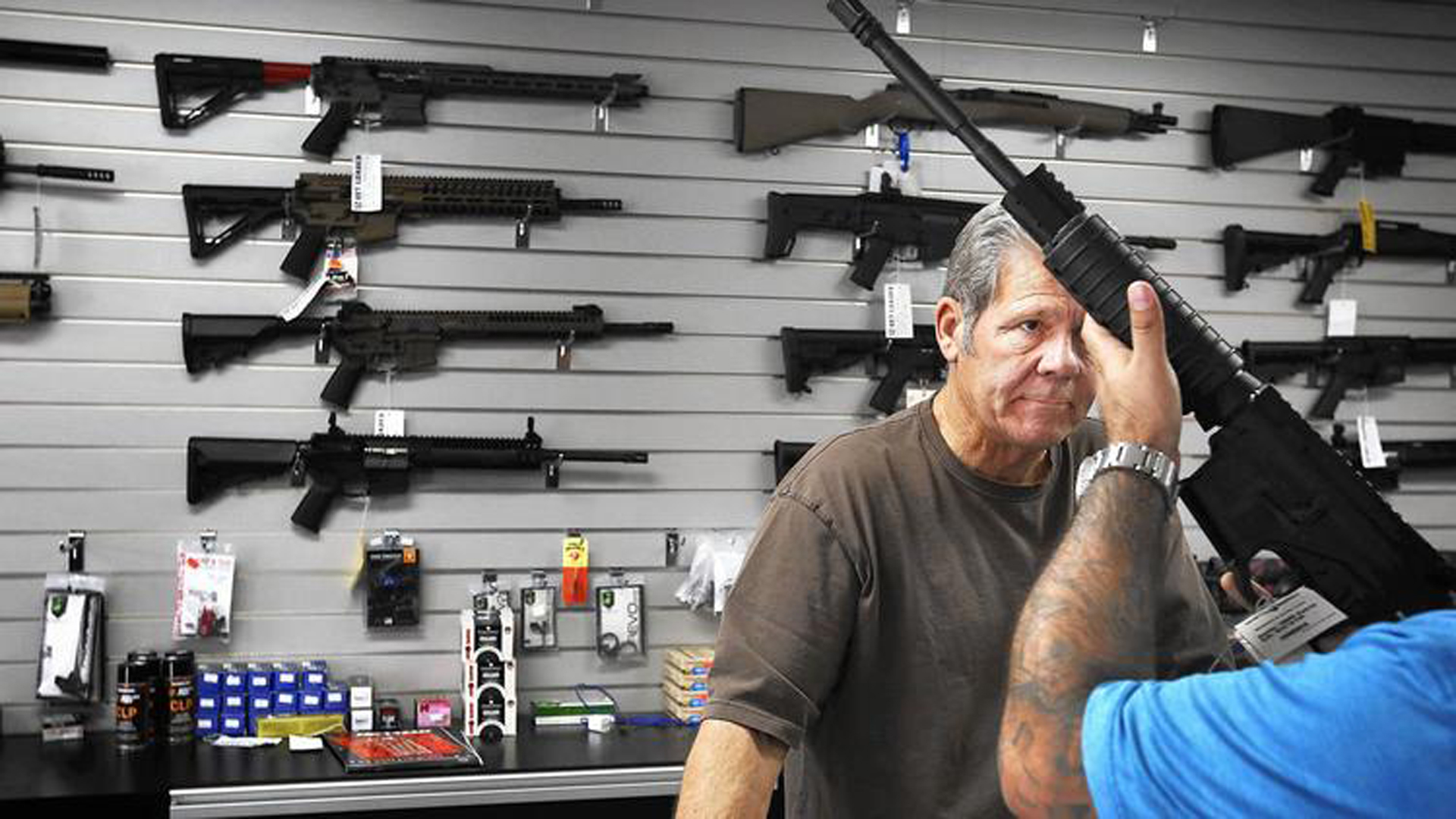 Frank Cobet of Get Loaded in Grand Terrace shows a customer a AR-15 rifle. store in Grand Terrace in 2015. (Credit: Barbara Davidson / Los Angeles Times)