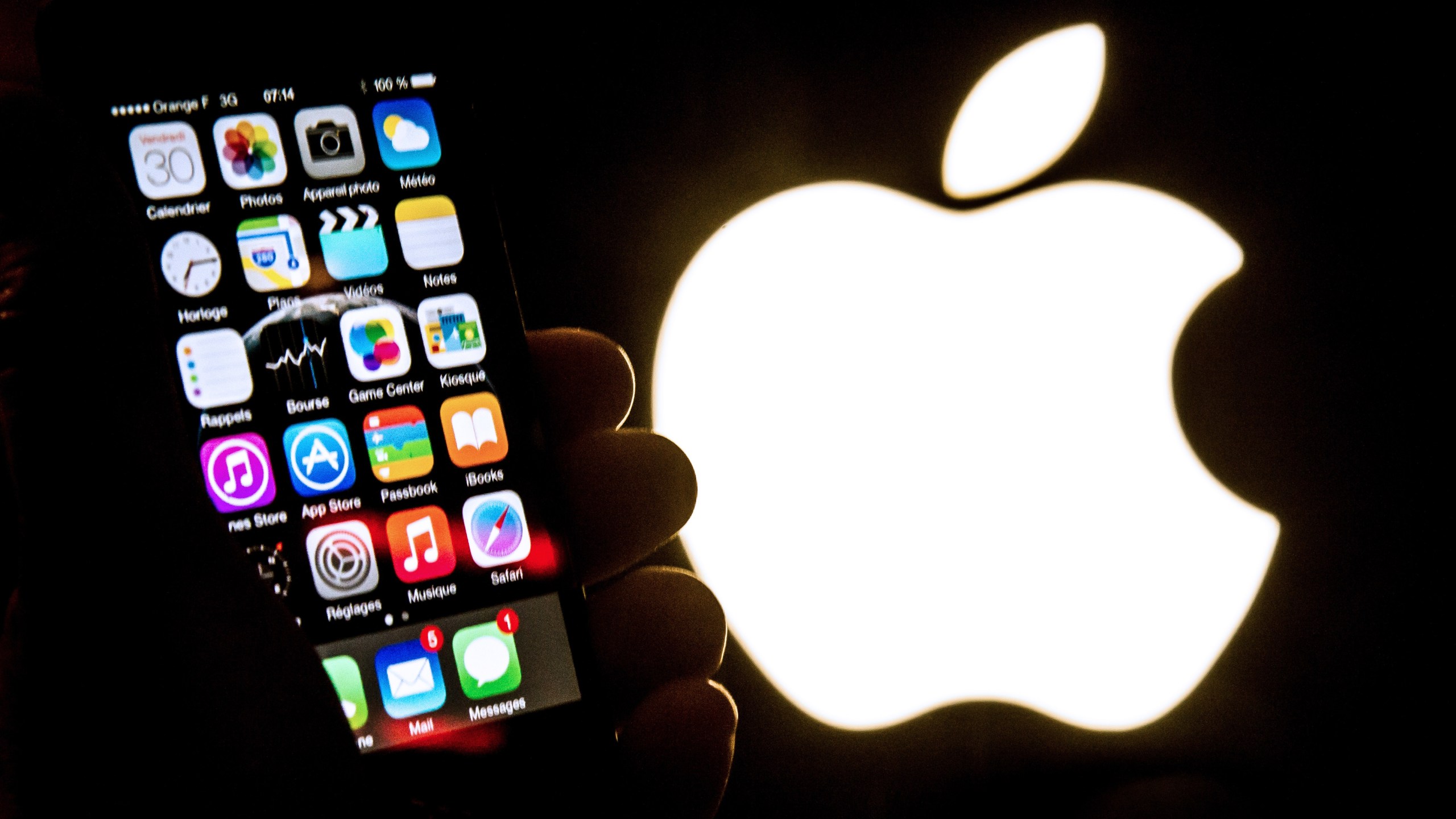 An illustration of an iPhone held up in front of the Apple Inc. logo taken Jan. 30, 2015. (Credit: PHILIPPE HUGUEN/AFP/Getty Images)