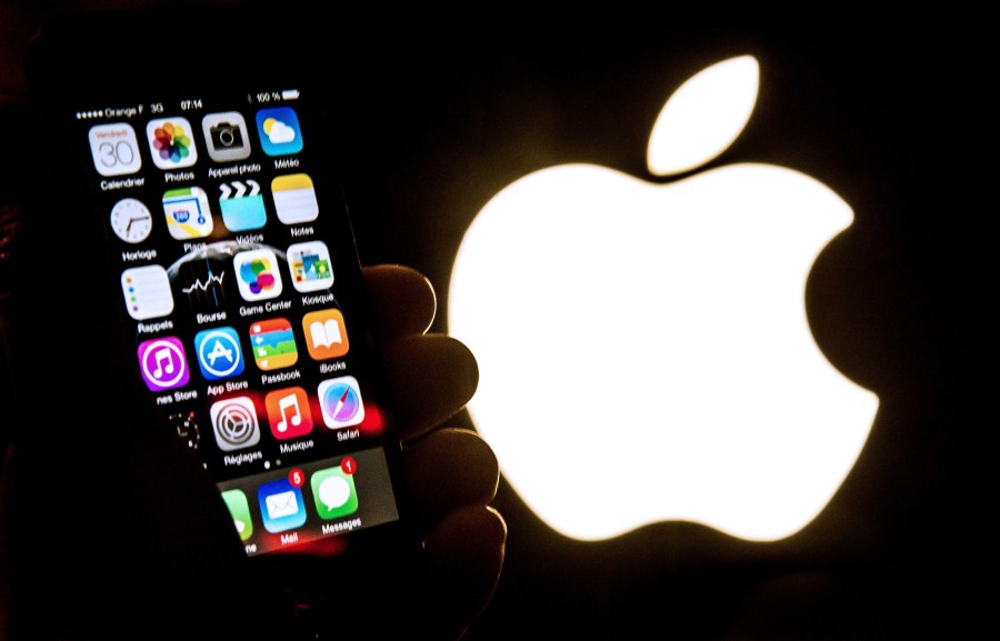 An illustration of an iPhone held up in front of the Apple Inc. logo taken Jan. 30, 2015. (Credit: PHILIPPE HUGUEN/AFP/Getty Images)