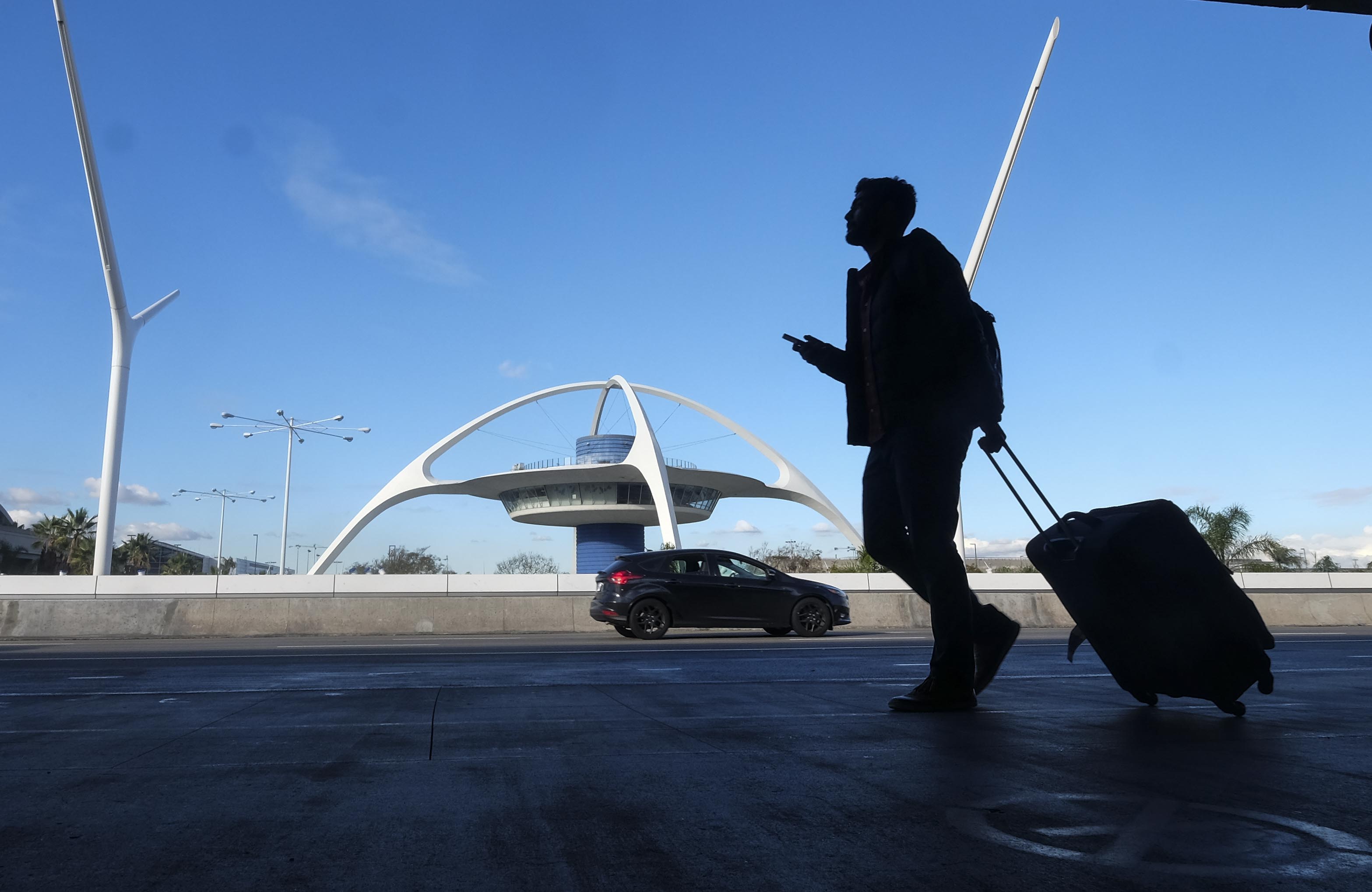 A traveler prepares to check in at Los Angeles International Airport on Dec. 22, 2016. (Credit: RINGO CHIU/AFP/Getty Images)