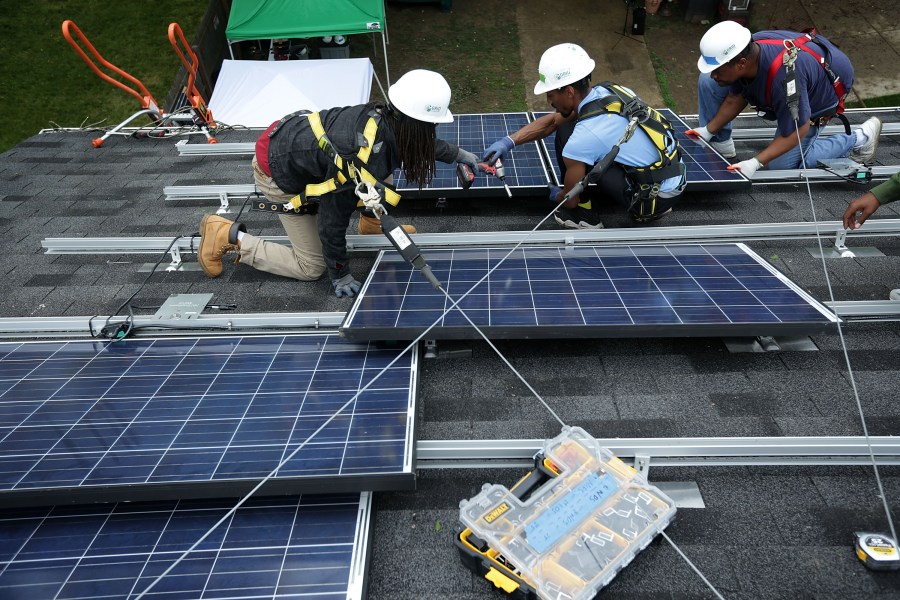 Workers put solar panels down during an installation on May 3, 2016, in Washington, DC. (Alex Wong / Getty Images)