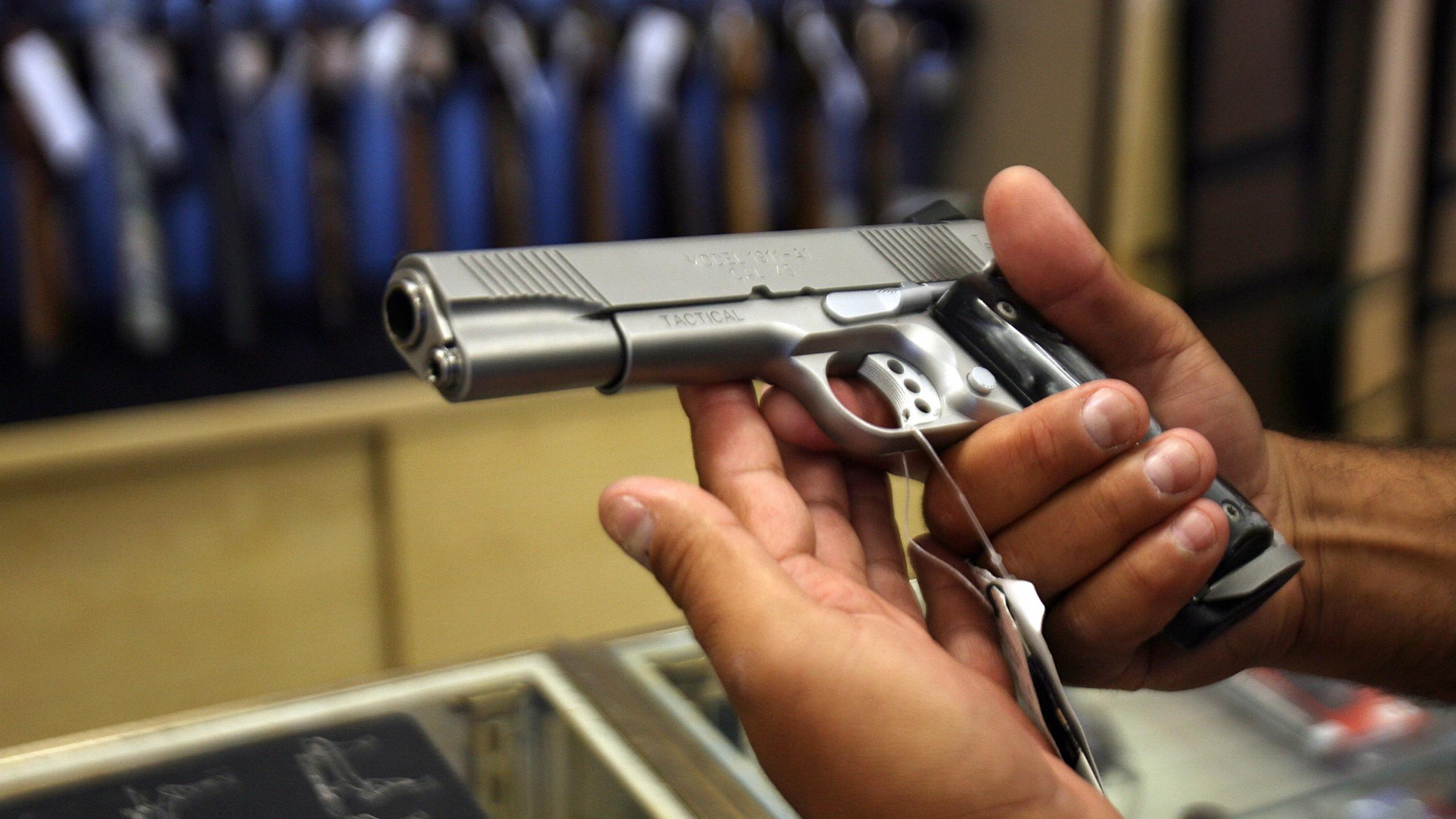 A man chooses a gun at the Gun Gallery in Glendale, California, April 18, 2007. (Credit: GABRIEL BOUYS/AFP/Getty Images)