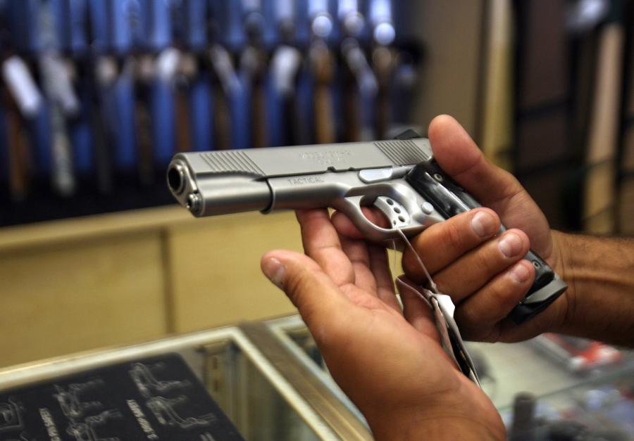 A man chooses a gun at the Gun Gallery in Glendale, California, April 18, 2007. (Credit: GABRIEL BOUYS/AFP/Getty Images)