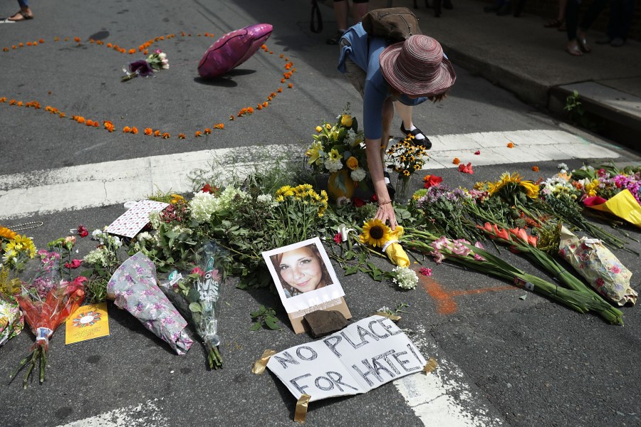 A woman places flowers at an informal memorial to 32-year-old Heather Heyer, who was killed when a car plowed into a crowd of people protesting against the white supremacist Unite the Right rally, August 13, 2017 in Charlottesville, Virginia. (Credit: Chip Somodevilla/Getty Images)