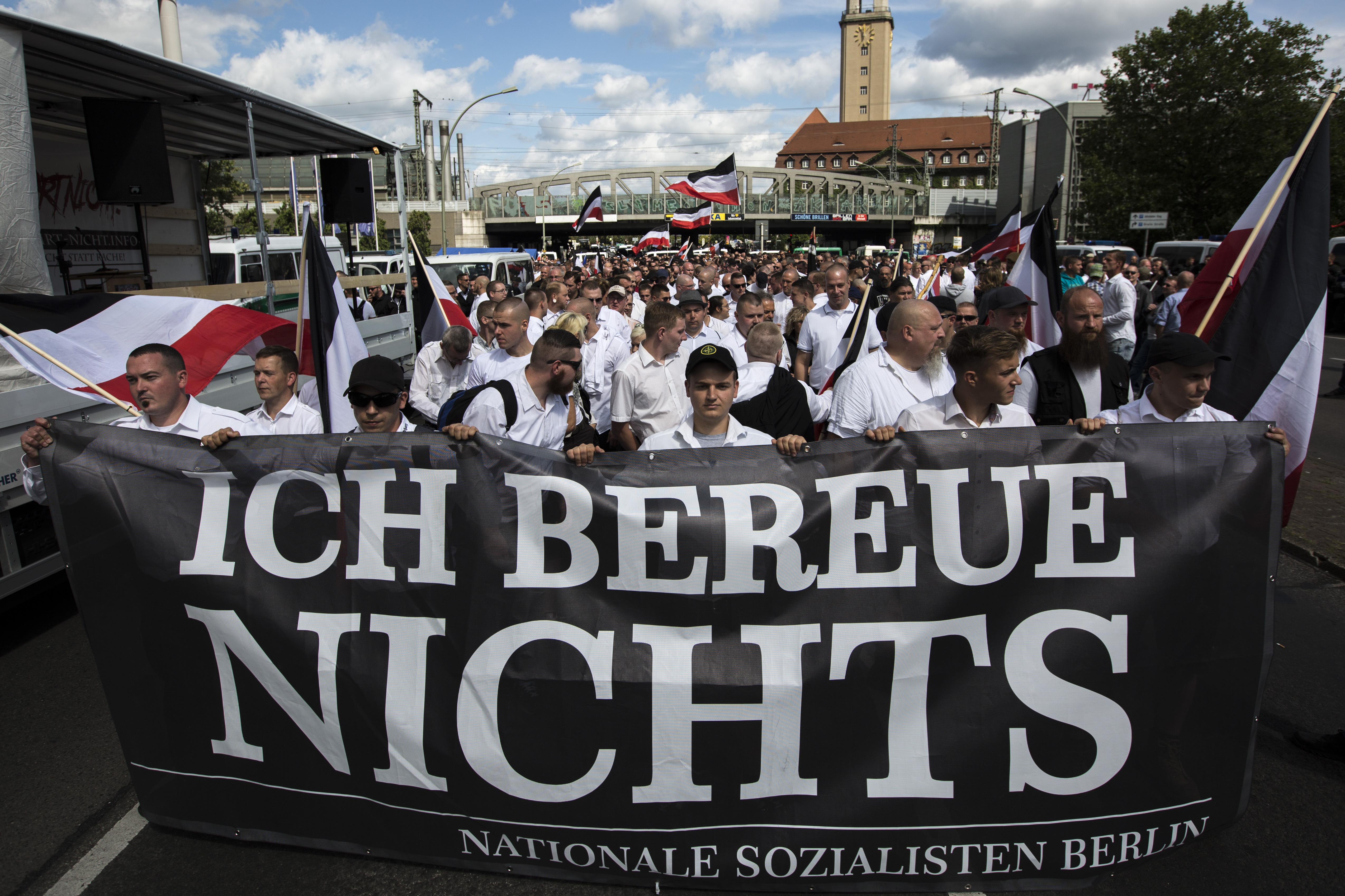 Some 1,000 participants affiliated with Neo-Nazi and extreme right groups marched through the street of Berlin, Germany, in commemoration of 30 years to Rudolf Hess's death, on Aug. 19, 2017. This group is seen carrying a sign reading "I regret nothing". (Credit: Omer Messinger / Getty Images)