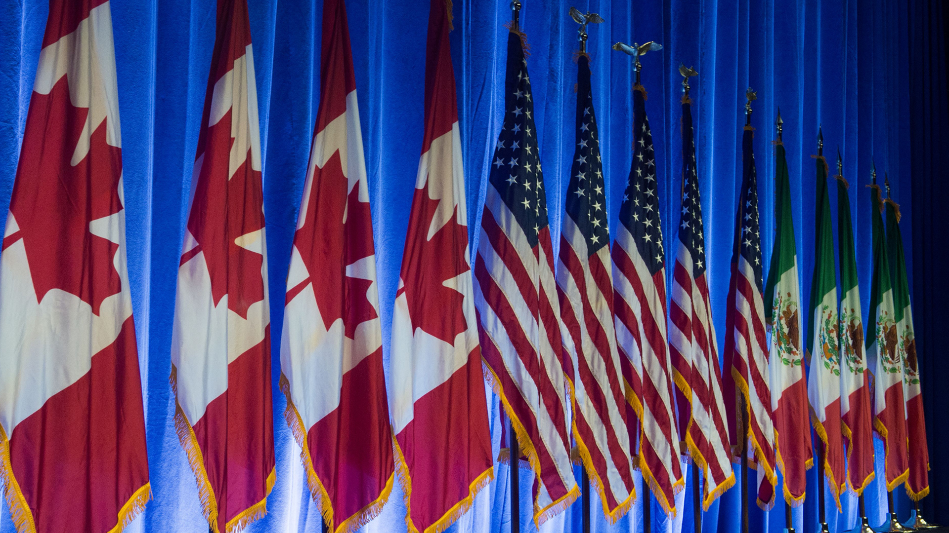 The flags of Canada, the United States and Mexico line the stage before the start of the negotiations for the modernization of NAFTA, Aug. 16, 2016, in Washington, DC. (Credit: Paul J. Richards / AFP / Getty Images)