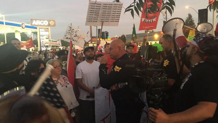 Fresno Police Chief Jerry Dyer acts as a buffer between protesters for and against the local appearance of former Arizona Sheriff Joe Arpaio on Sept. 29, 2017. (Credit: Brittny Mejia / Los Angeles Times)