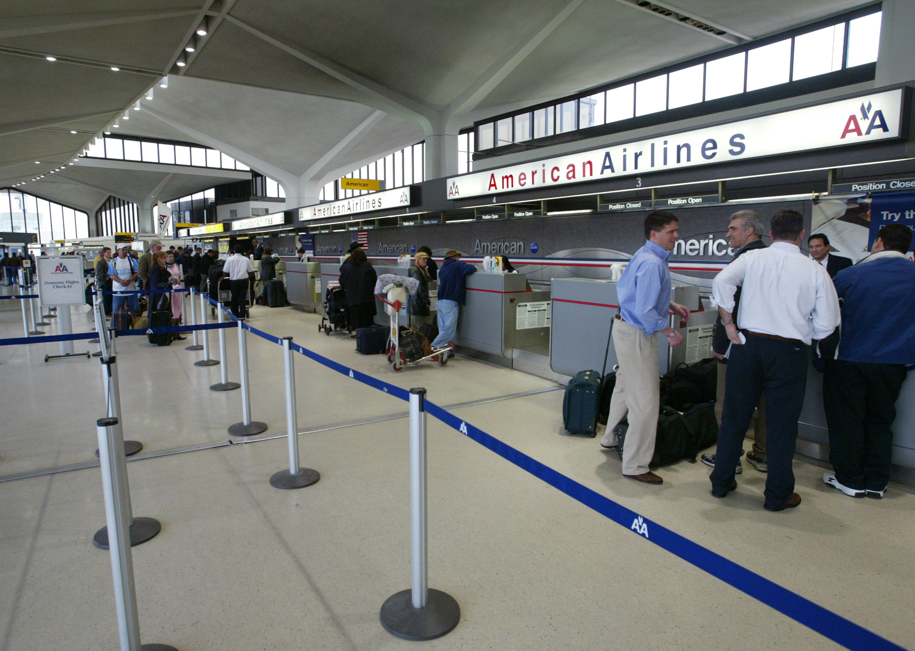 Passengers wait at a ticket counter at Newark Liberty International Airport on April 3, 2003. (Credit: Matthew Peyton/Getty Images)