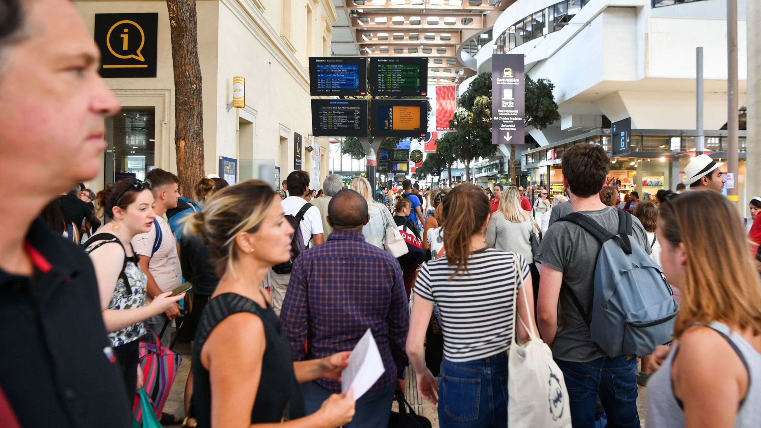 Passengers look at information monitors as they wait for their trains at The Saint-Charles Station in Marseille on Aug. 20, 2017. (Credit: Bertrand Langlois / AFP / Getty Images)