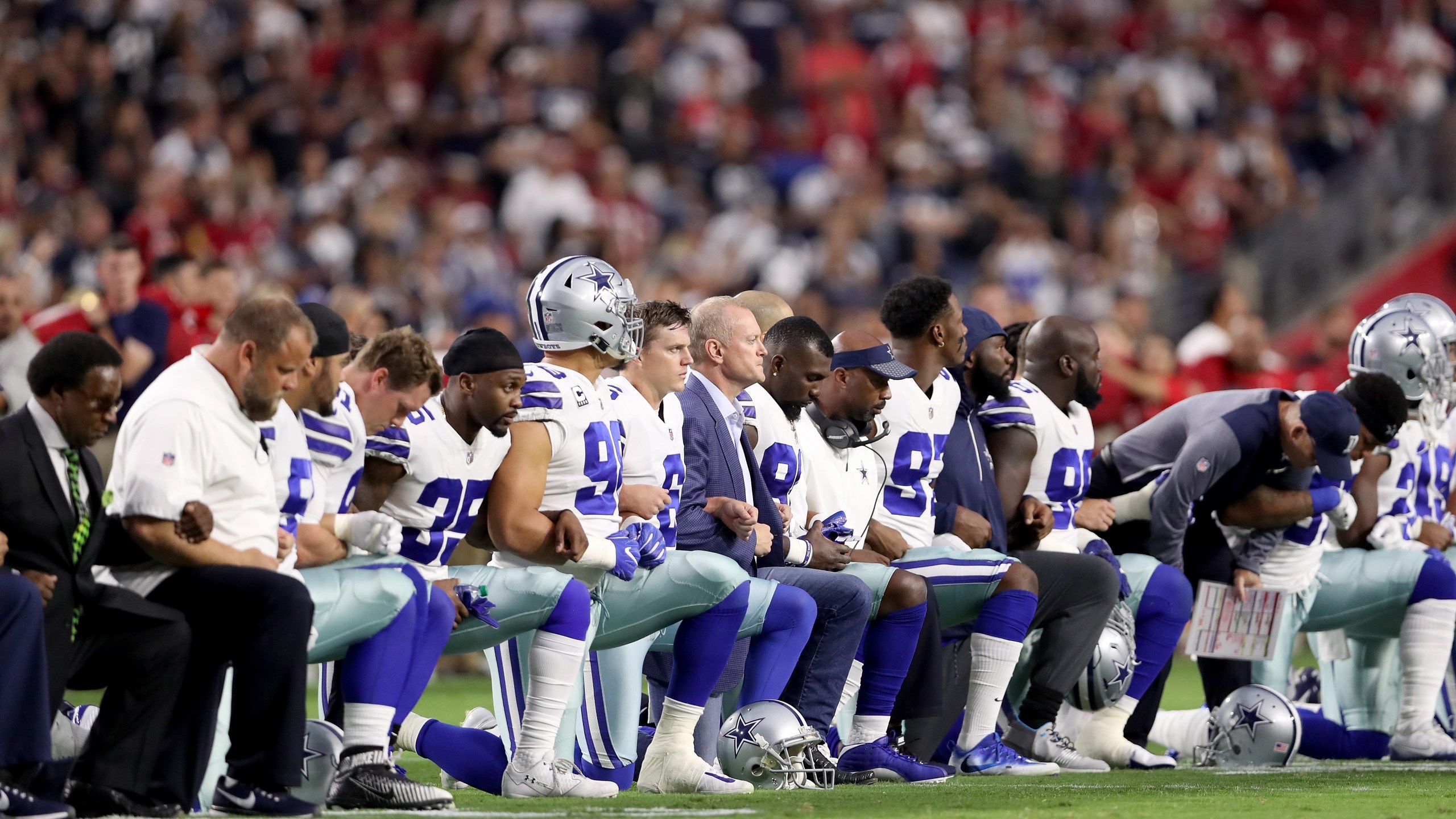 Members of the Dallas Cowboys link arms and kneel during the National Anthem before the start of the NFL game against the Arizona Cardinals at the University of Phoenix Stadium on September 25, 2017 (Credit: Christian Petersen/Getty Images)