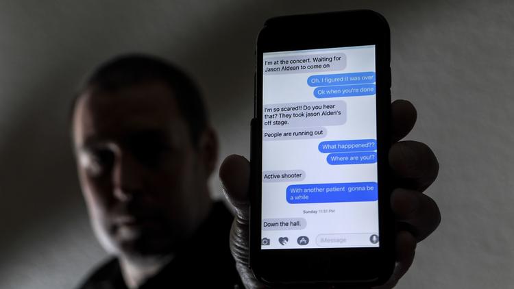 J.C. Monticone holds up his phone showing a text from his fiancee, who was attending the Route 91 Harvest country music festival in Las Vegas. (Credit: Irfan Khan / Los Angeles Times)