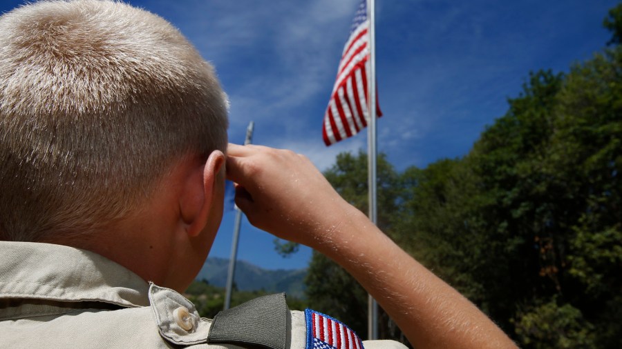 A Boy Scout salutes the American flag at camp Maple Dell on July 31, 2015 outside Payson, Utah. (Credit: George Frey/Getty Images)