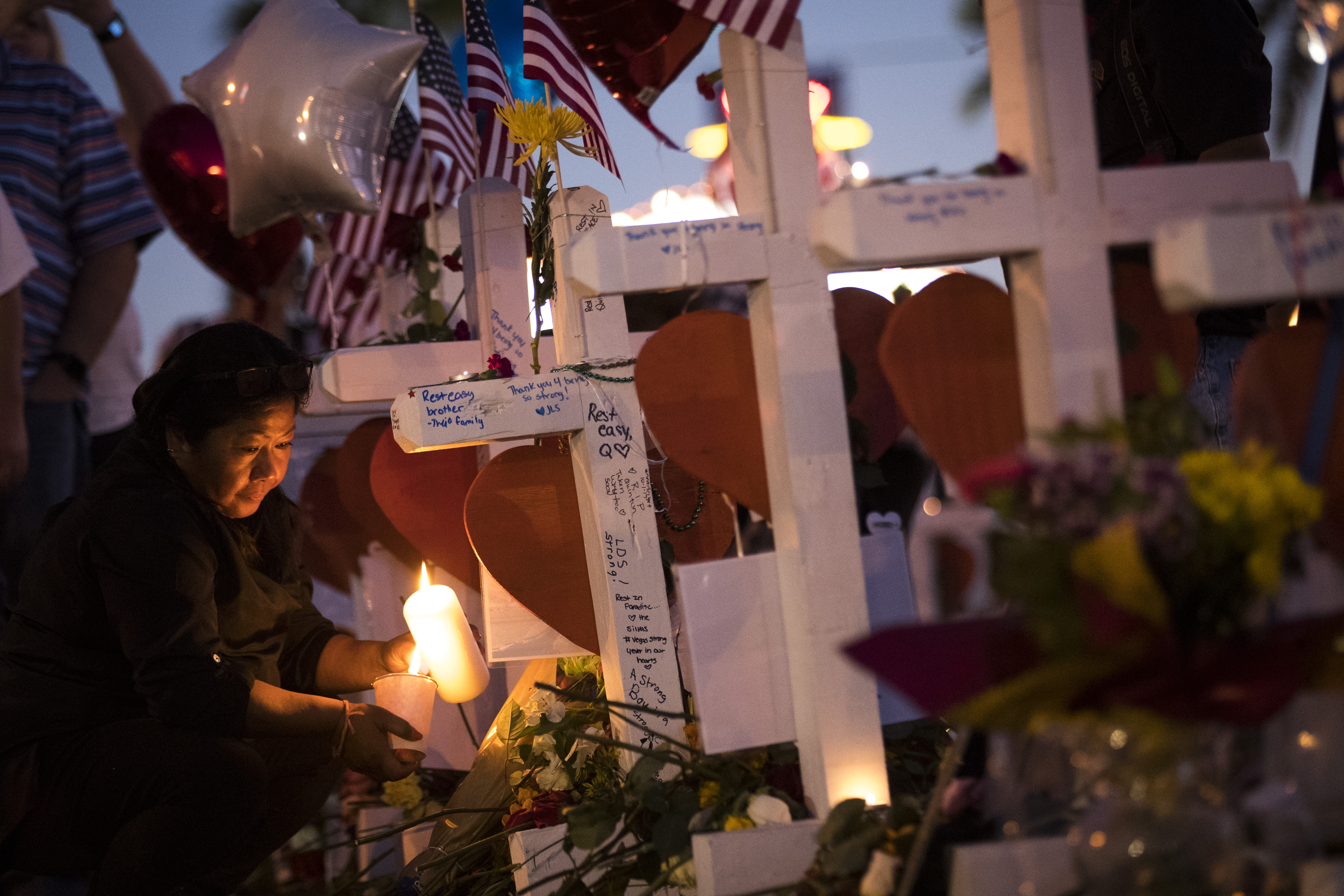 A woman lights candles at several of the 58 white crosses at a makeshift memorial on the south end of the Las Vegas Strip, Oct. 6, 2017 in Las Vegas, Nevada. (Credit: Drew Angerer / Getty Images)