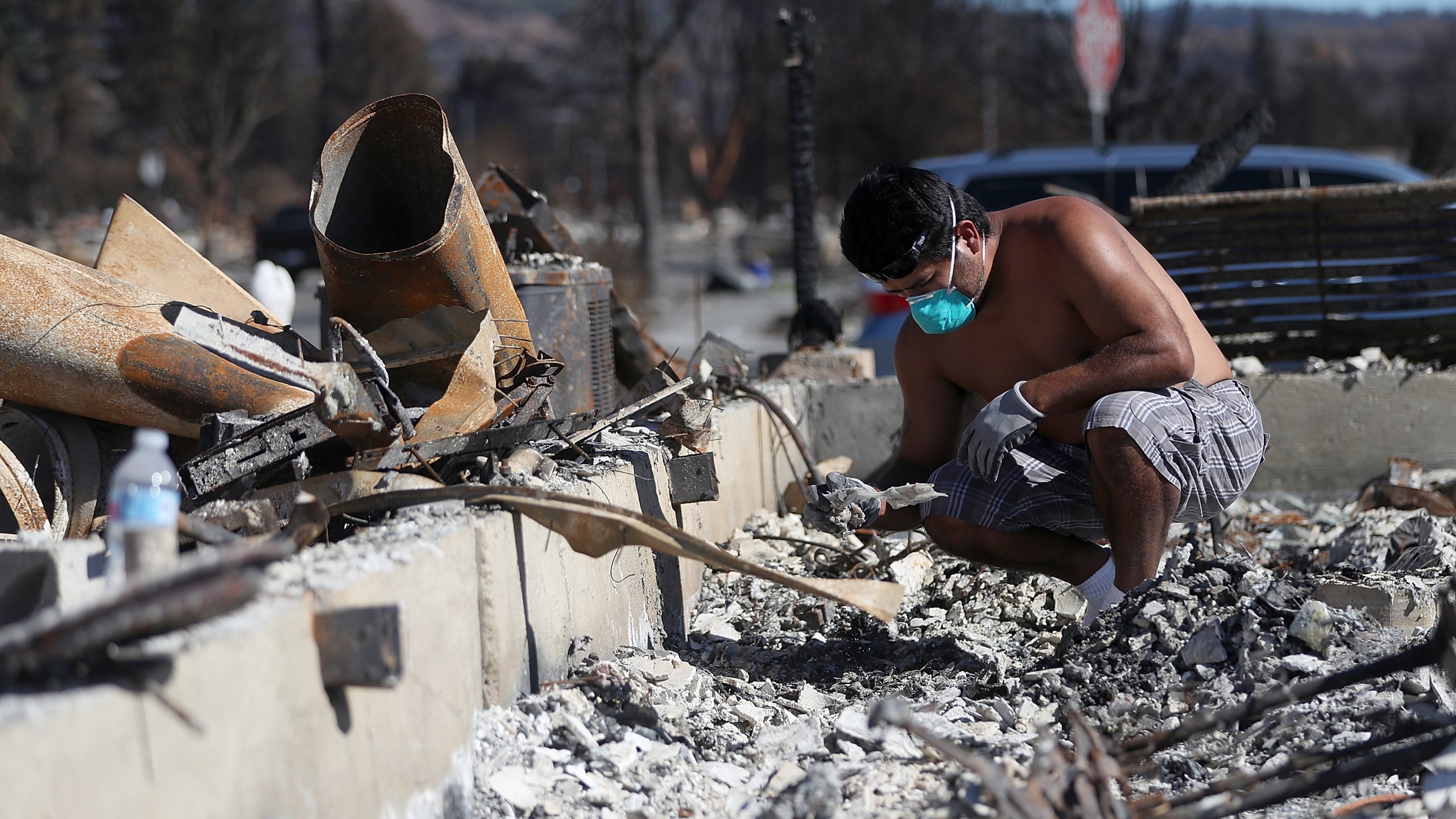 Ben Hernandez sifts through the remains of his Coffey Park home that was destroyed by the Tubbs Fire on Oct. 23, 2017, in Santa Rosa. (Credit: Justin Sullivan / Getty Images)