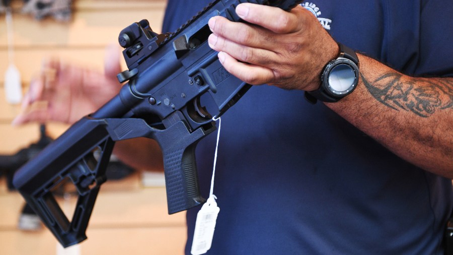 Gun salesman Mark Warner shows a bump stock installed on an AR-15 rifle at Blue Ridge Arsenal in Chantilly, Virgina, on Oct. 6, 2017. (Credit: Jim Watson/AFP/Getty Images)