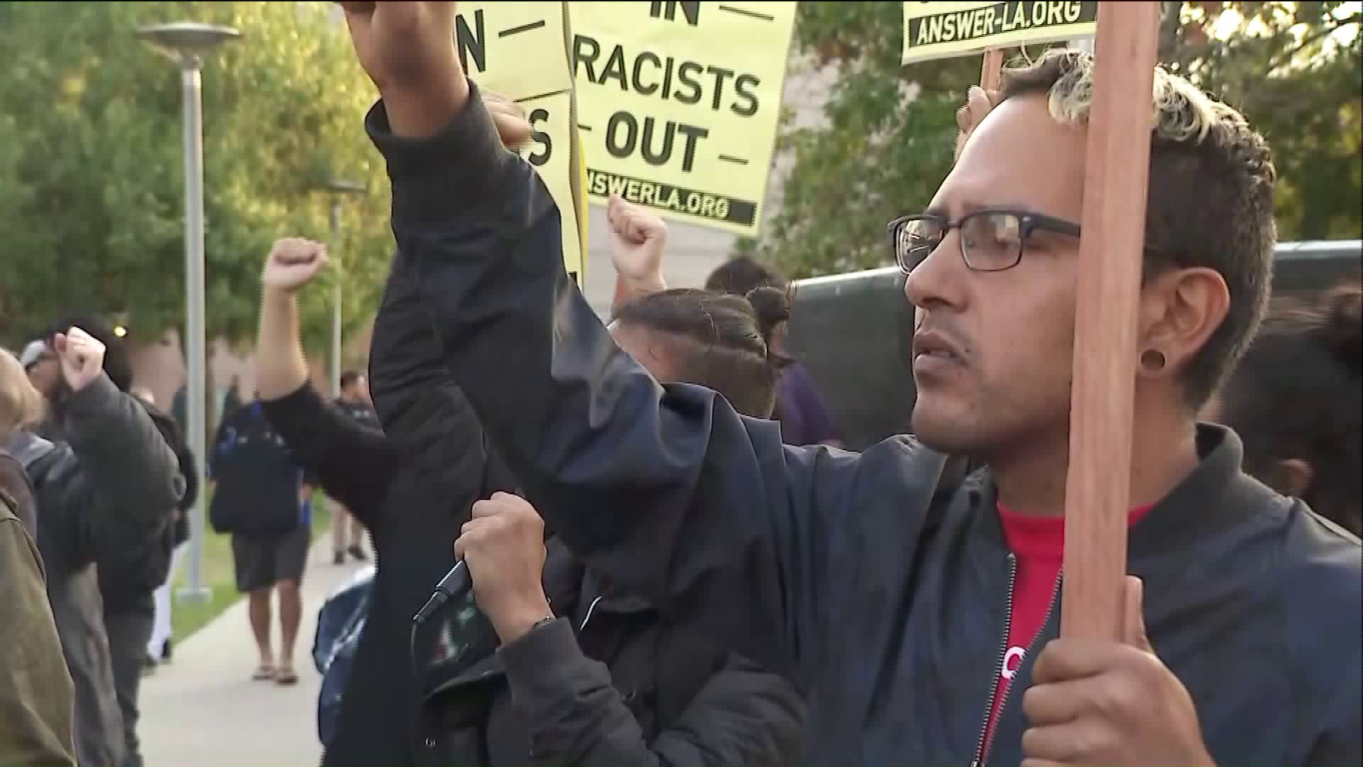 A student protests at Cal State Fullerton the arrival of speaker Milo Yiannopoulos, a controversial figure with a following of far-right conservatives, nativists and white supremacists. (Credit: KTLA)