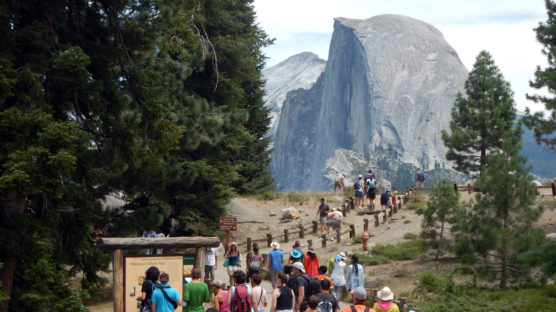 This Aug. 5, 2015, photo shows tourists walking out to Glacier Point with a background view of Half Dome at Yosemite National Park. (Credit: FREDERIC J. BROWN/AFP/Getty Images)