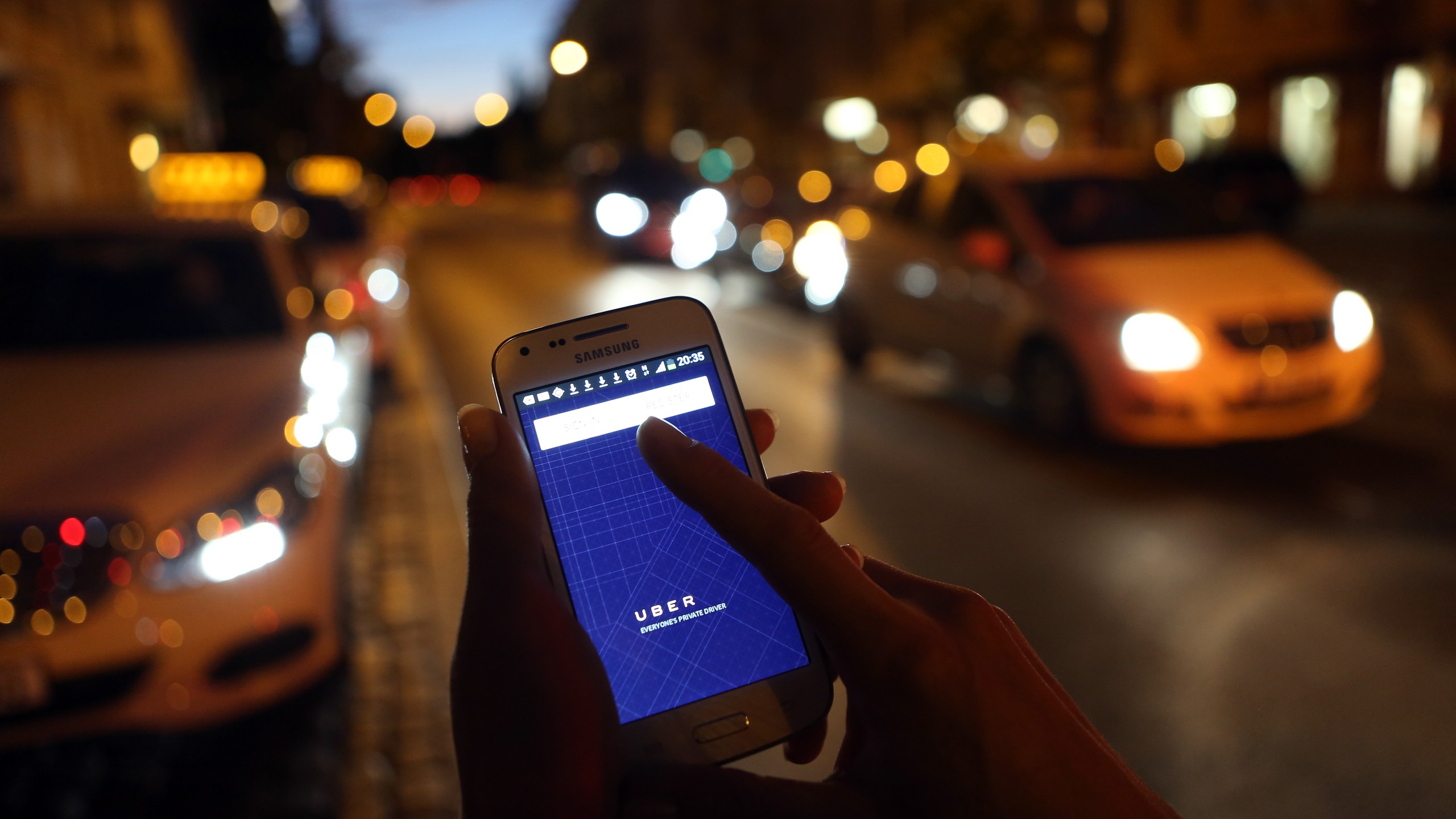 In this photo illustration, a woman uses the Uber app on Sept. 2, 2014, in Berlin, Germany. (Credit: Adam Berry / Getty Images)