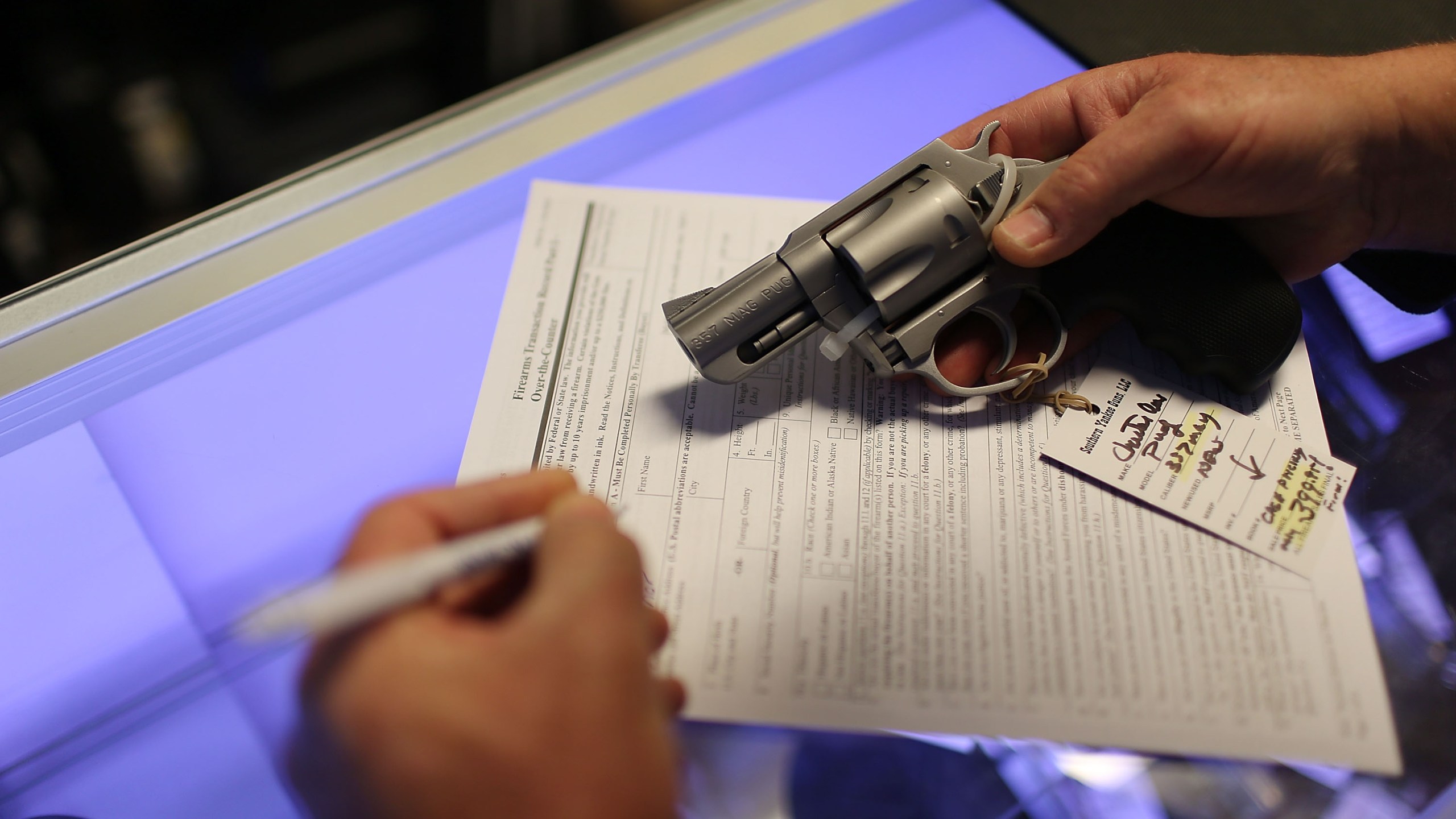 Mark O'Connor fills out his federal background check paperwork as he purchases a handgun at K&W Gunworks in Delray Beach, Florida, on the day President Barack Obama announced his executive action on guns, Jan. 5, 2016. (Credit: Joe Raedle / Getty Images)