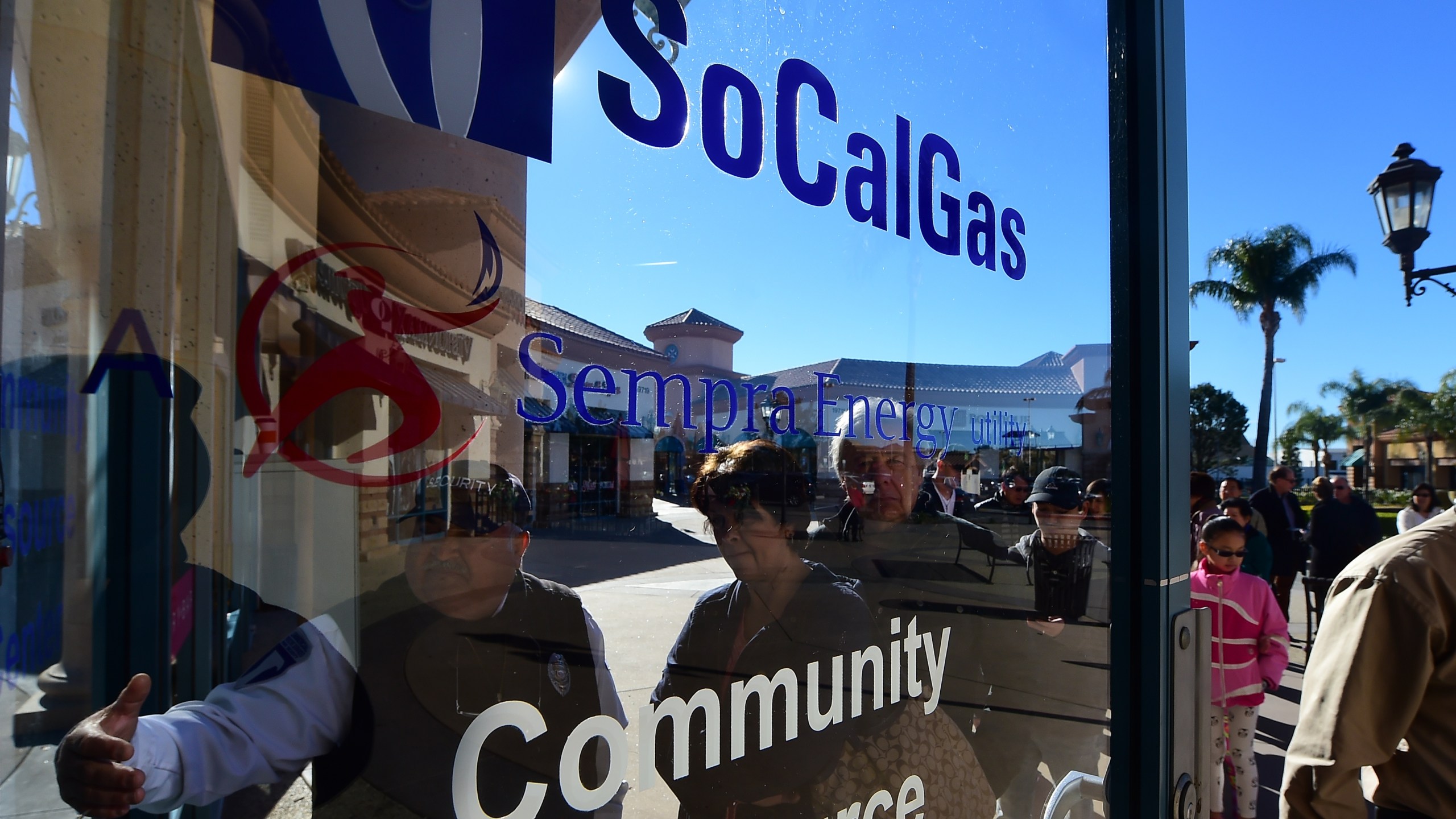 A security guard gestures the way in for Porter Ranch residents arriving at the SoCal Gas Community Resource Center in Porter Ranch, California on Jan. 8, 2016, where residents have been going to lodge complaints and seek an alternative housing situation from their homes near where natural gas leaking from a well has sickened and displaced thousands of residents. (Credit: FREDERIC J. BROWN/AFP/Getty Images)