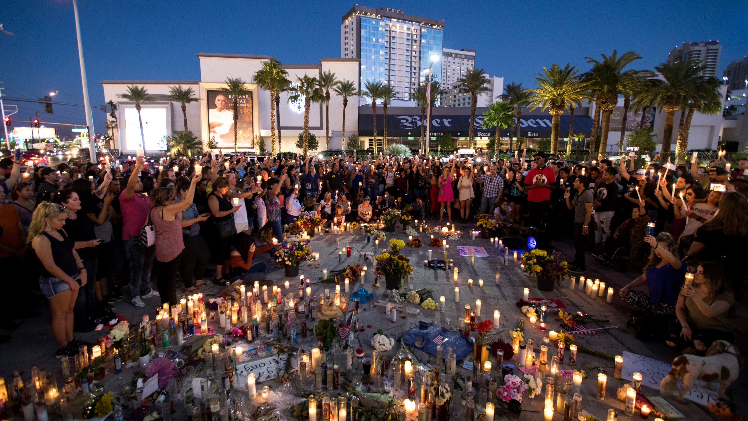 Mourners hold their candles in the air for a moment of silence during a vigil on the Las Vegas Strip to mark one week since the mass shooting at the Route 91 Harvest country music festival, Oct. 8, 2017. (Credit: Drew Angerer / Getty Images)