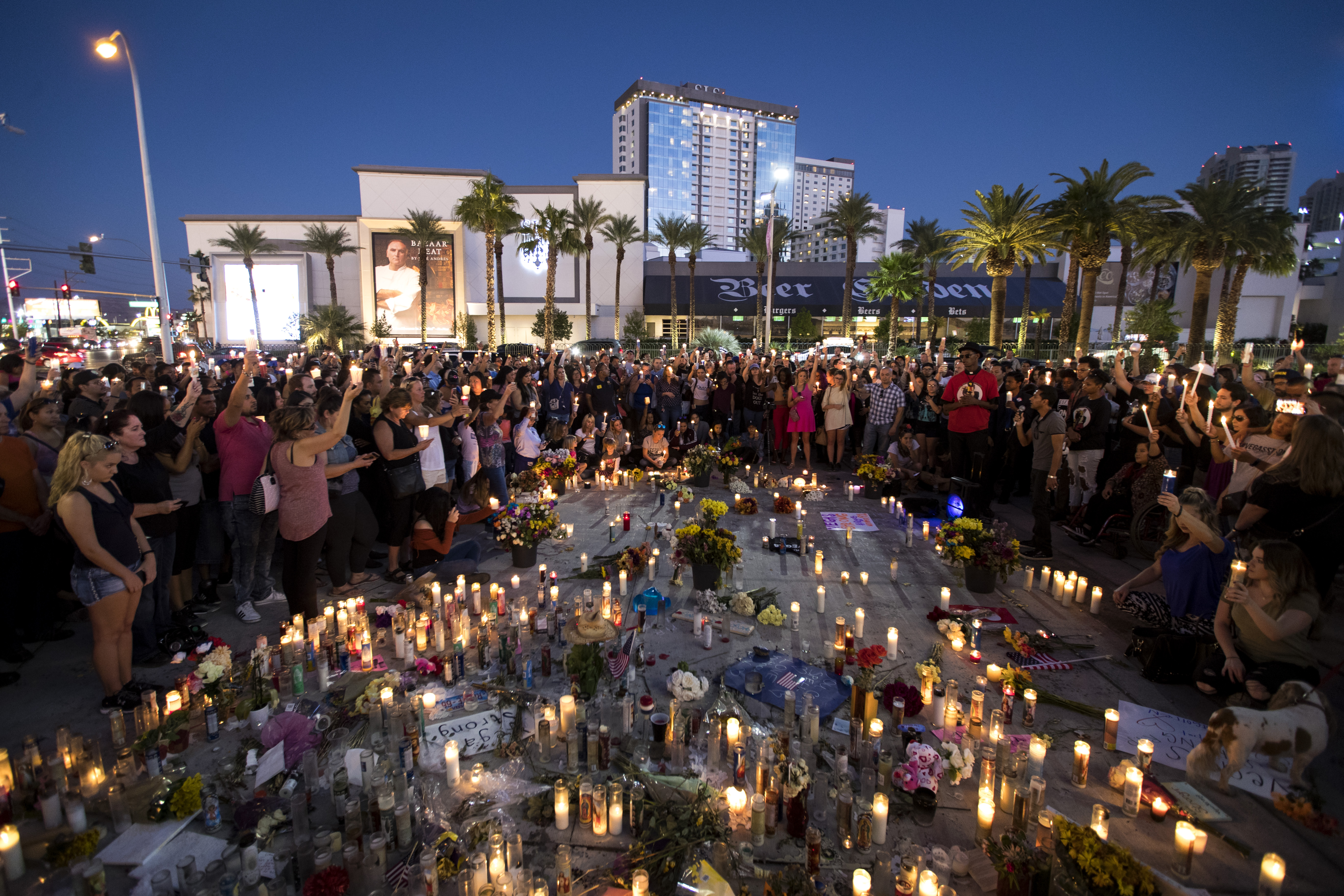 Mourners hold their candles in the air for a moment of silence during a vigil on the Las Vegas Strip to mark one week since the mass shooting at the Route 91 Harvest country music festival, Oct. 8, 2017. (Credit: Drew Angerer / Getty Images)