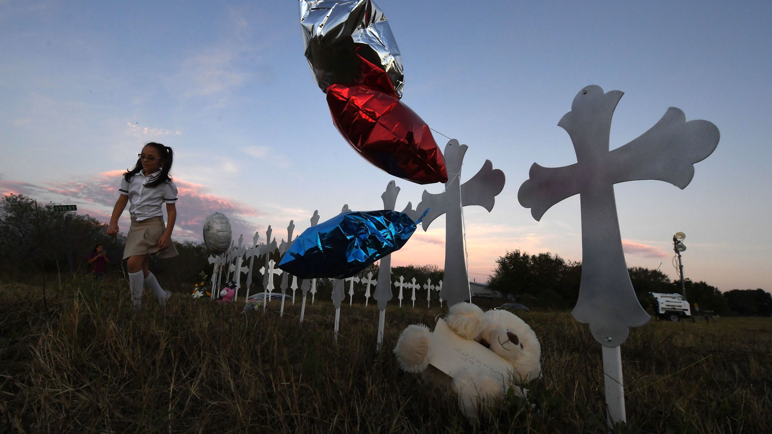 Heather Cooper, 8, leaves after placing her favorite doll on a row of crosses for each victim, after a mass shooting that killed 26 people in Sutherland Springs, Texas on November 6, 2017. (Credit: MARK RALSTON/AFP/Getty Images)