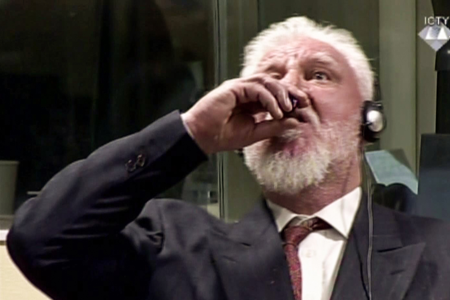 Court footage from the International Criminal Court shows Croatian former general Slobodan Praljak swallowing what is believed to be poison, during his judgement at the UN war crimes court to protest the upholding of a 20-year jail term. (Credit: AFP PHOTO / ICTY / Getty Images)