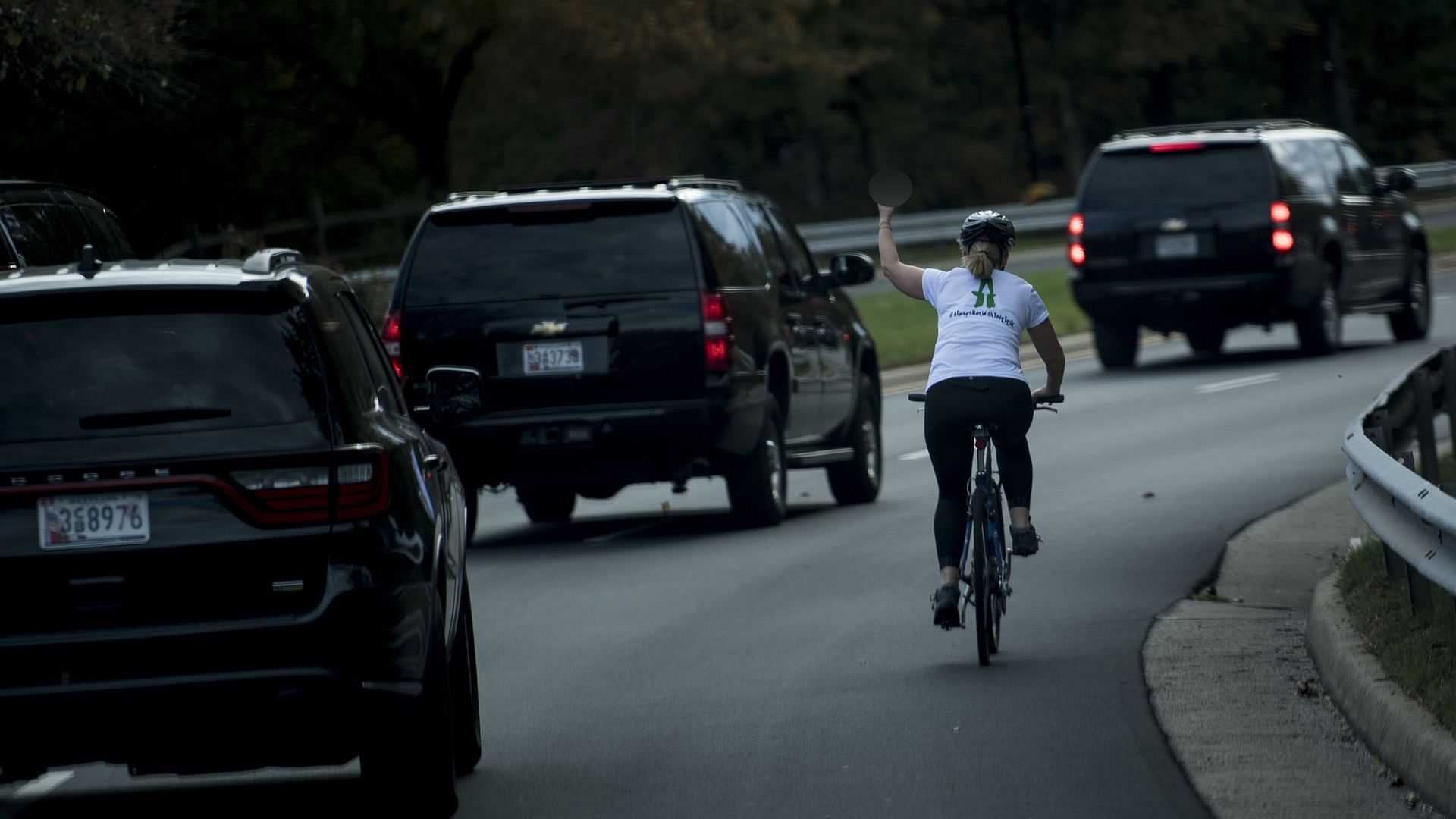 Juli Briskman gestures with her middle finger as a motorcade with U.S. President Donald Trump departs Trump National Golf Course Oct. 28, 2017, in Sterling, Virginia. (Credit: Brendan Smialowski / AFP / Getty Images)