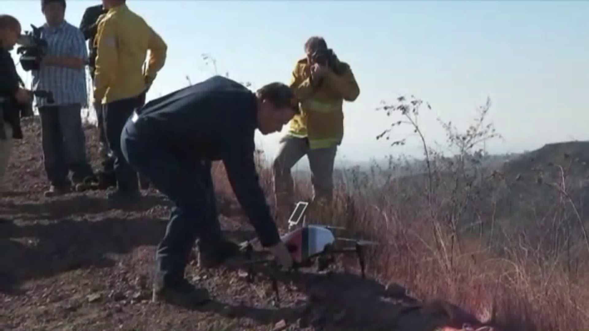 Los Angeles Fire Department officials display one of the agency's drones on Dec. 14, 2017, in Bel-Air, near where the Skirball Fire burned. (Credit: KTLA)