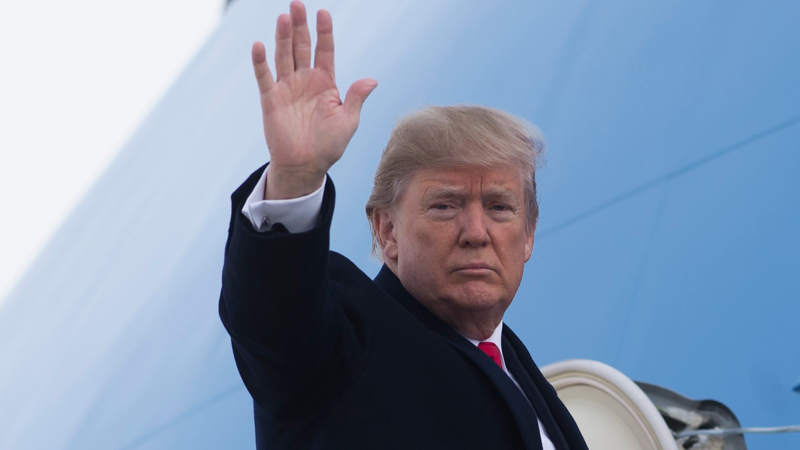 Donald Trump waves from Air Force One prior to departure from Andrews Air Force Base in Maryland on Dec. 4, 2017. (Credit: Saul Loeb/AFP/Getty Images)