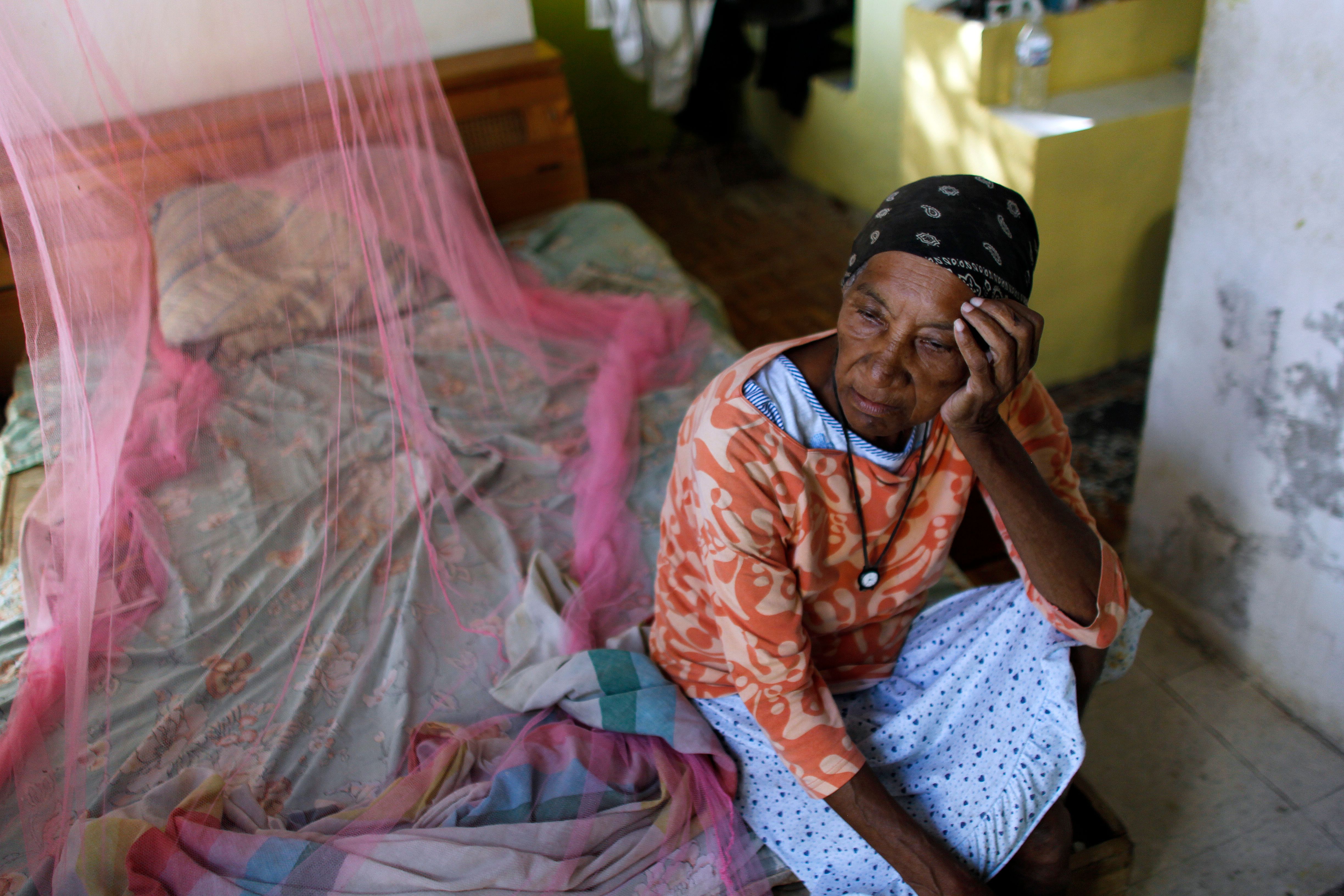 Aurea Cruz, 66, sits on her bed inside her house damaged by Hurricane Maria in Vieques, Puerto Rico, on Nov. 26, 2017. (Credit: Ricardo Arduengo / AFP / Getty Images)