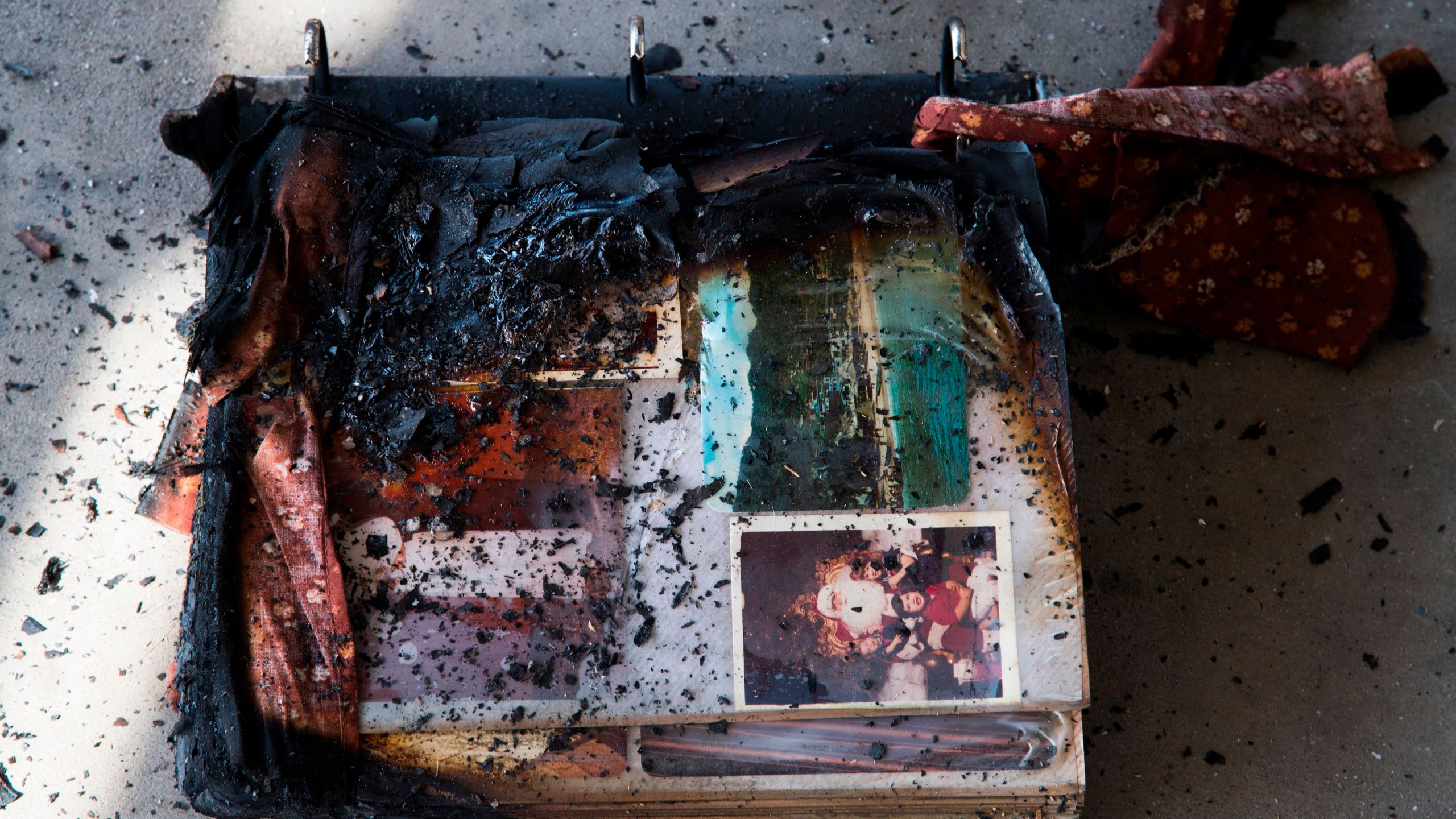 A photo album damaged by fire is see amid the destruction of the Lilac Fire, Dec. 8, 2017, at a retirement community in Fallbrook. (Credit: AFP PHOTO / Robyn Beck)