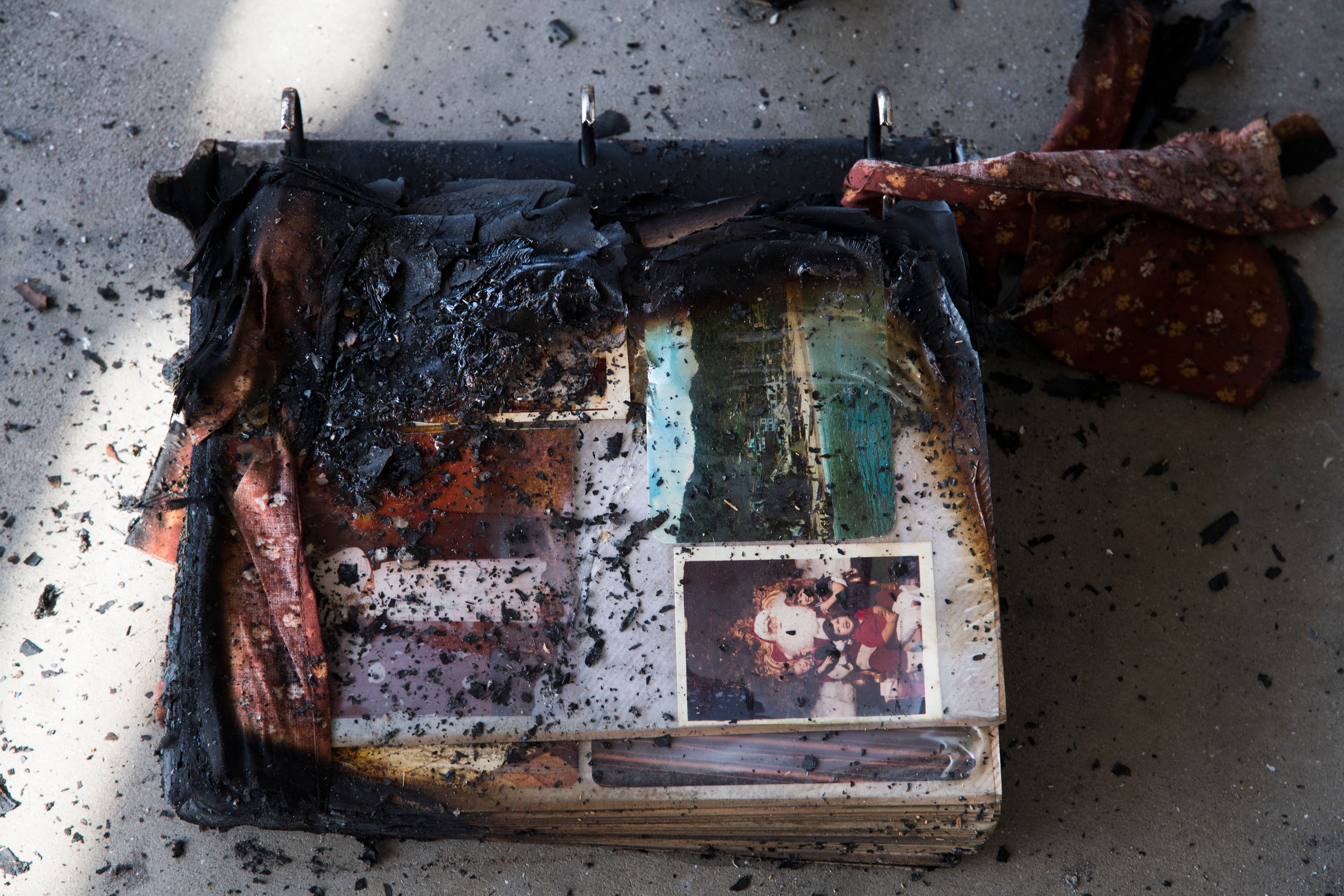 A photo album damaged by fire is see amid the destruction of the Lilac Fire, Dec. 8, 2017, at a retirement community in Fallbrook. (Credit: AFP PHOTO / Robyn Beck)