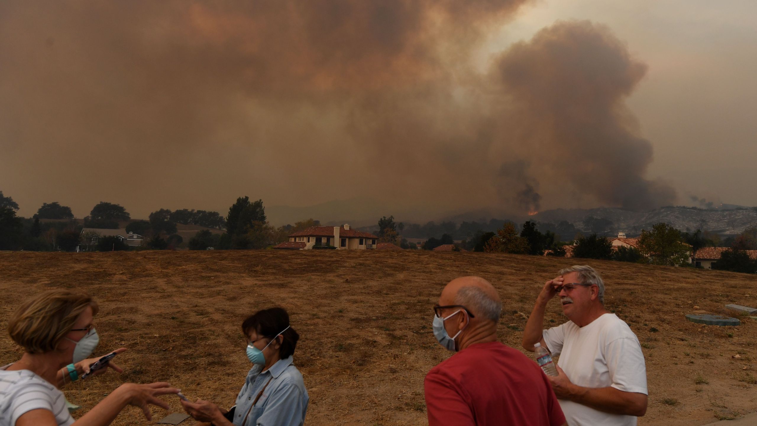 Local residents keep watch while fire and smoke from the Thomas wildfire heads towards their housing estate in Ojai on Dec. 9, 2017. (Credit: Mark Ralston / AFP / Getty Images)