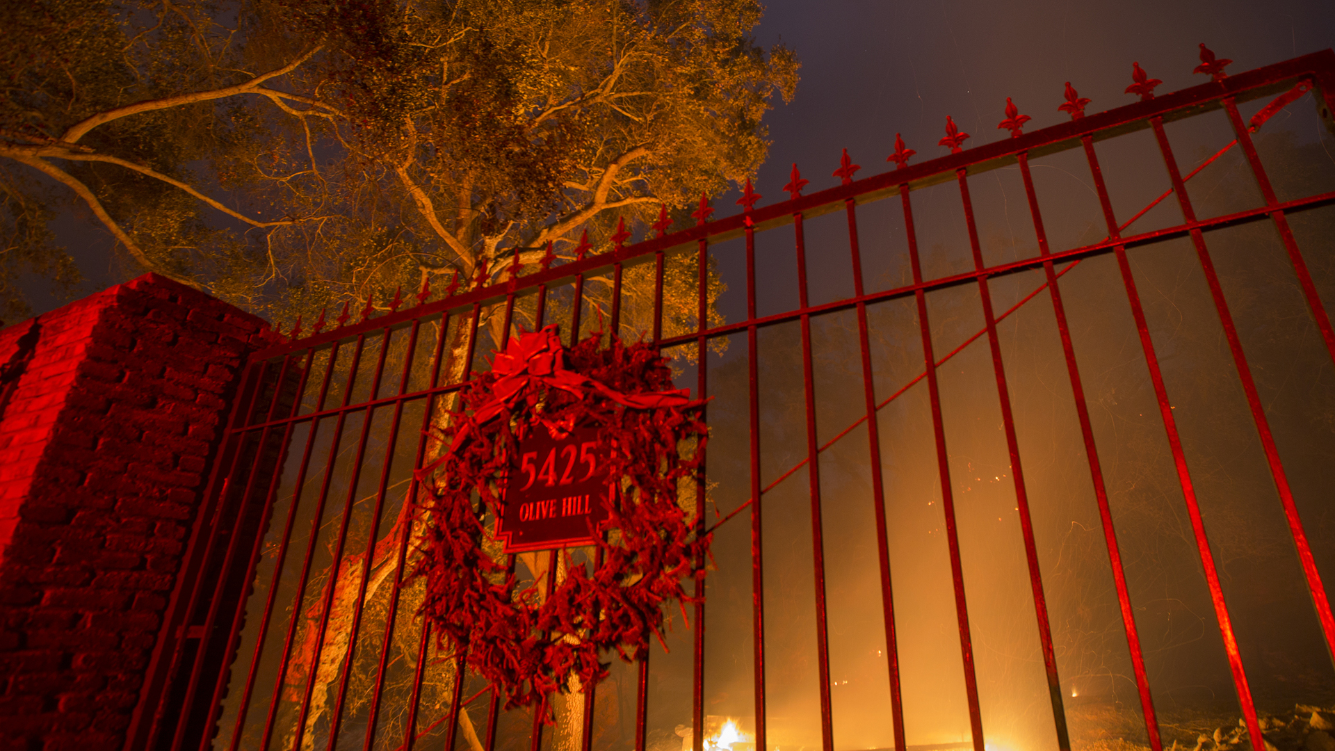 A wreath hangs on the gate of a burned property at the Lilac Fire in the early morning hours of Dec. 8, 2017, near Bonsall in San Diego County. (Credit: David McNew/Getty Images)