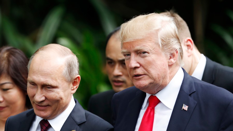 U.S. President Donald Trump and Russia's President Vladimir Putin walk together to take part in the "family photo" during the Asia-Pacific Economic Cooperation leaders' summit in the central Vietnamese city of Danang on Nov. 11, 2017. (Credit: Jorge Silva/AFP/Getty Images)