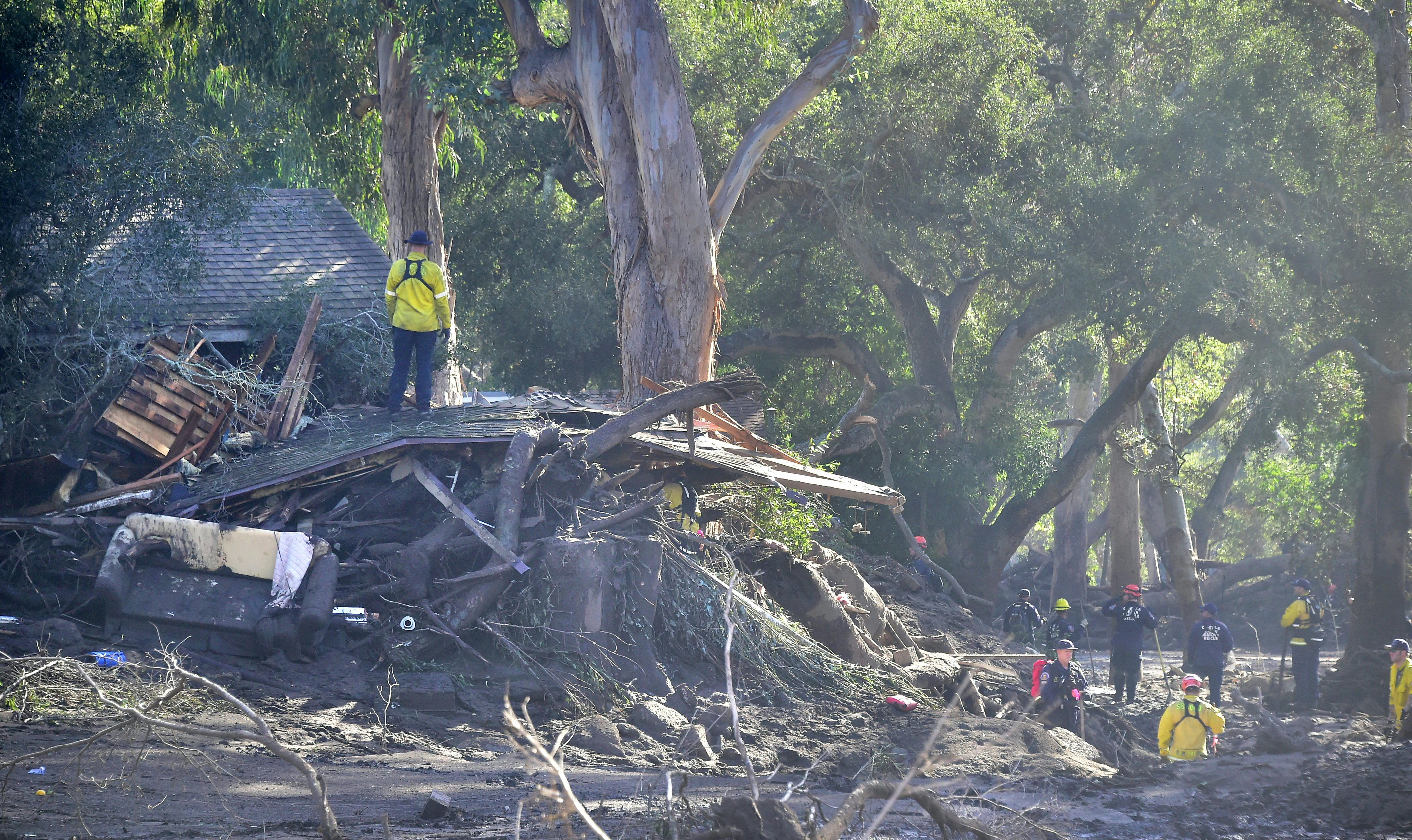 Search and rescue workers look through the debris of a demolished neighborhood in Montecito on Jan. 12, 2018. (Credit: Frederic J. Brown / AFP / Getty Images)