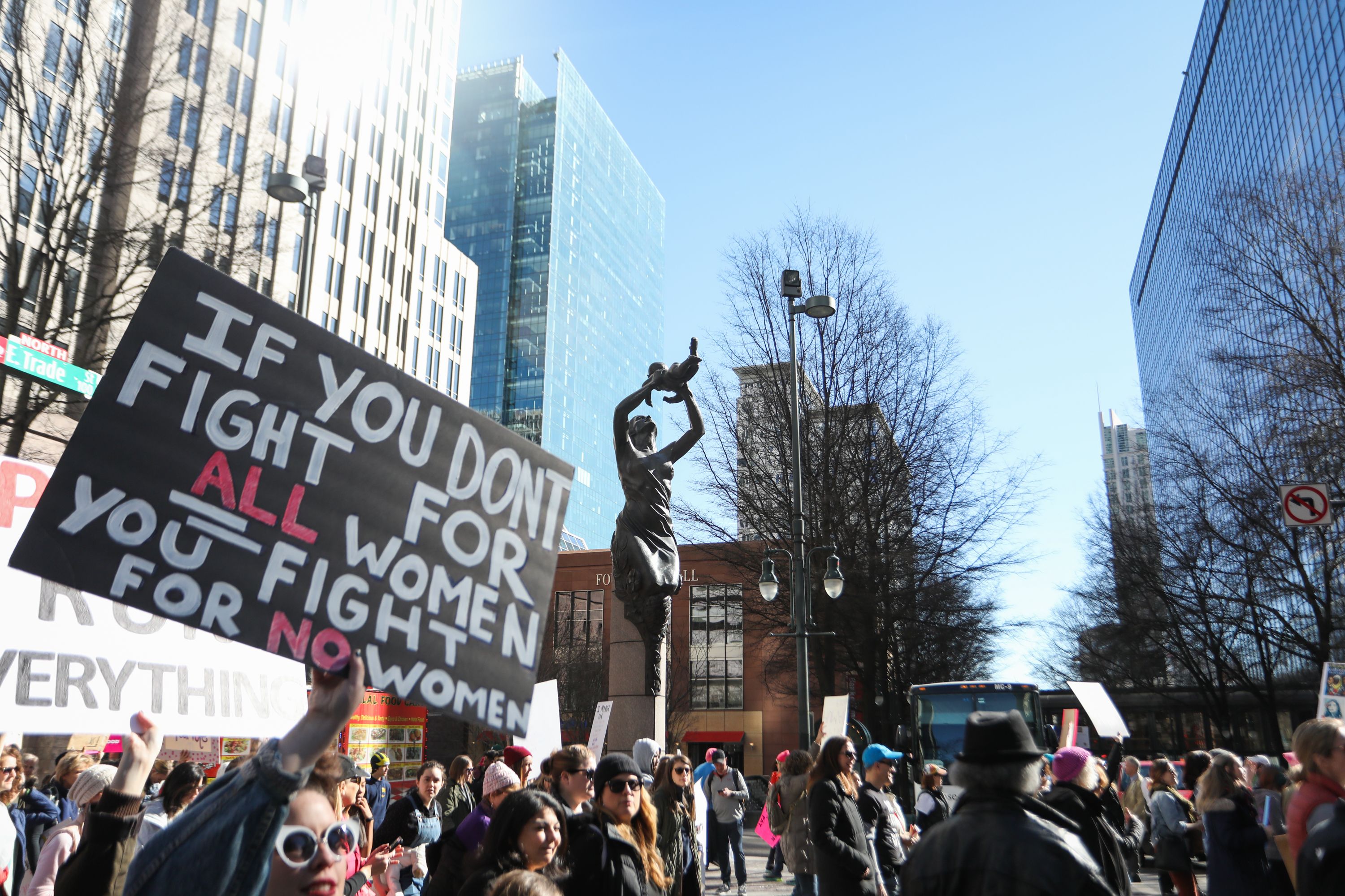 Marchers pass by a sculpture of a mother and child titled "The Future" during during the Remarchable Women rally in Charlotte, North Carolina on Jan. 20, 2018, marking the one-year anniversary of the Women's March. (Credit: Logan Cyrus/AFP/Getty Images)