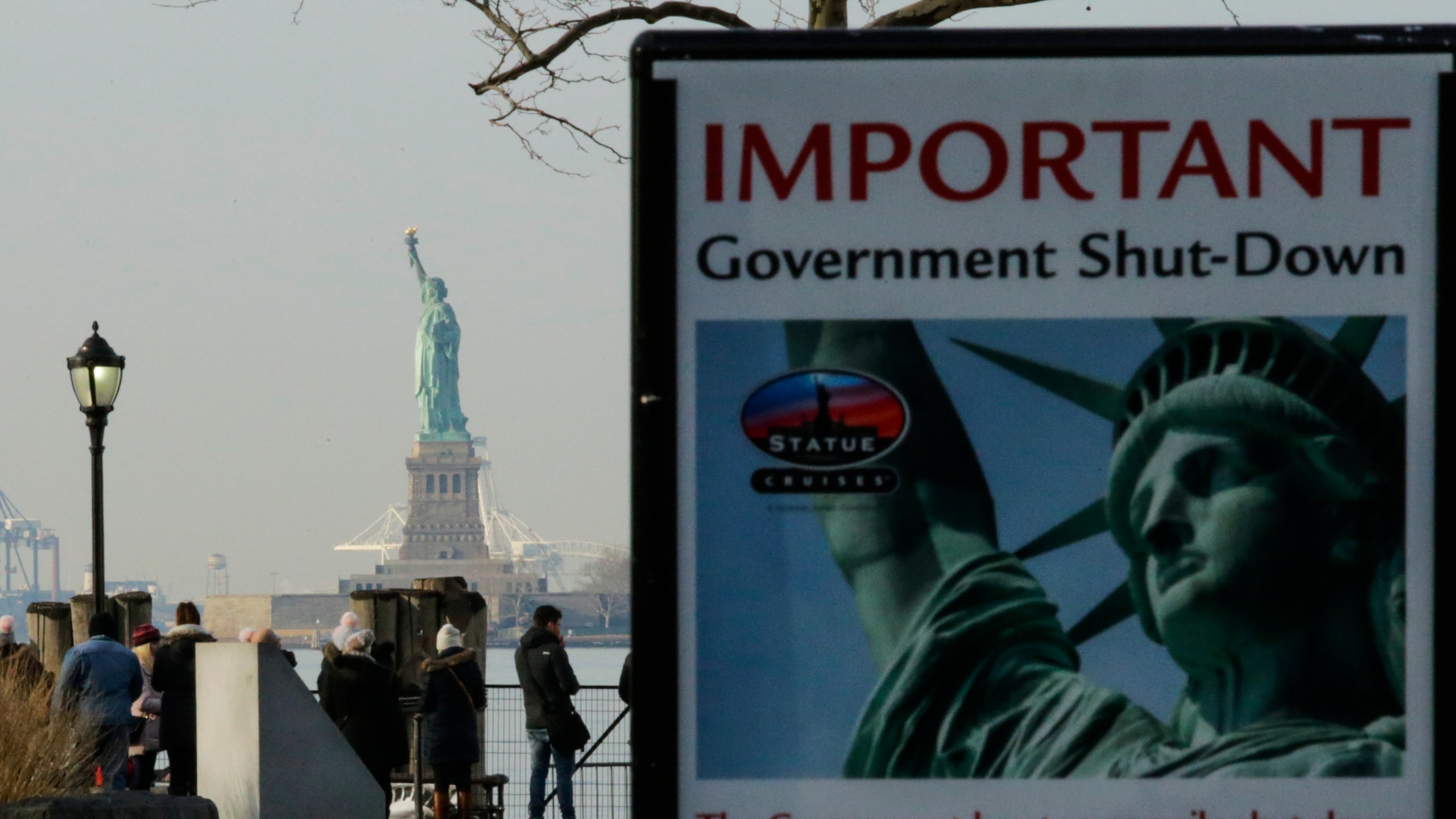 A placard is seen at the entrance of the Liberty State ferry terminal as people look on in New York City on Jan. 21, 2018. (Credit: Eduardo Munoz Alvarez / Getty Images)