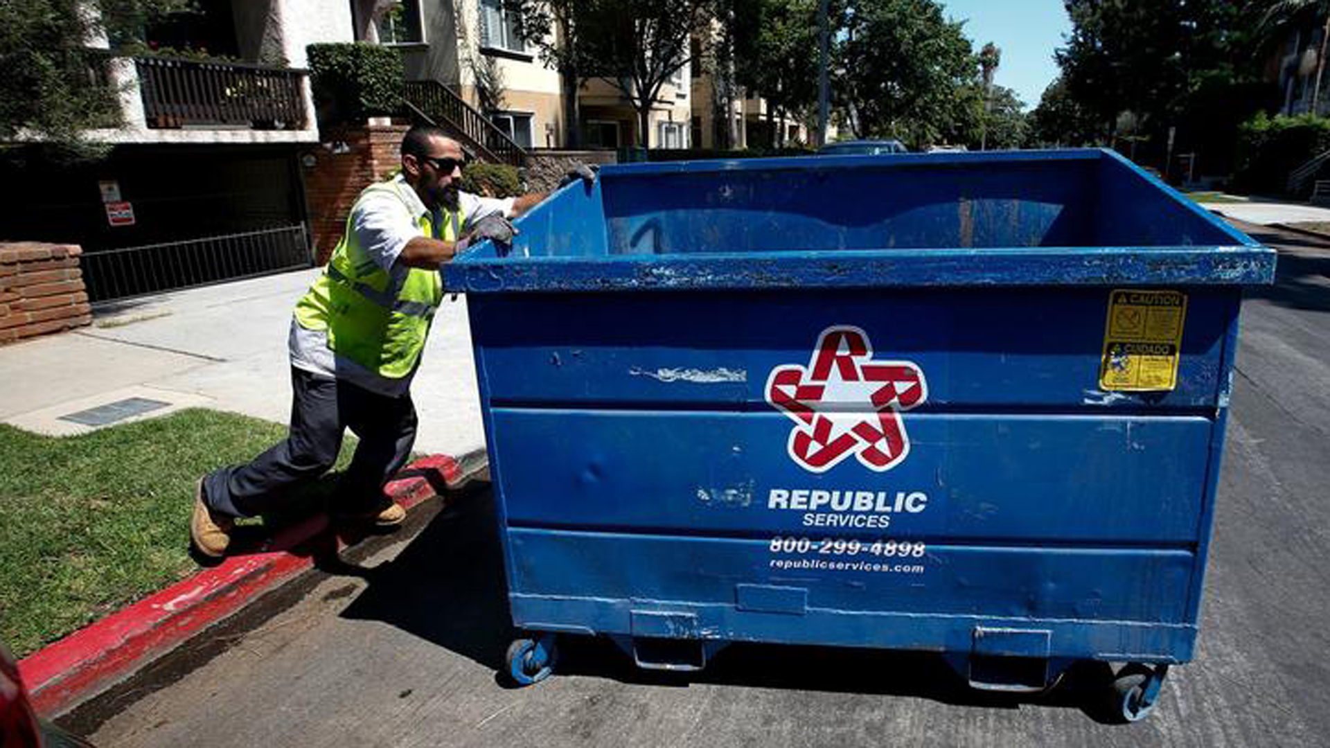 A man who works for Athen Services trash company moves a bin to where it will be picked up in West L.A. in this undated photo. (Credit: Mel Melcon / Los Angeles Times)