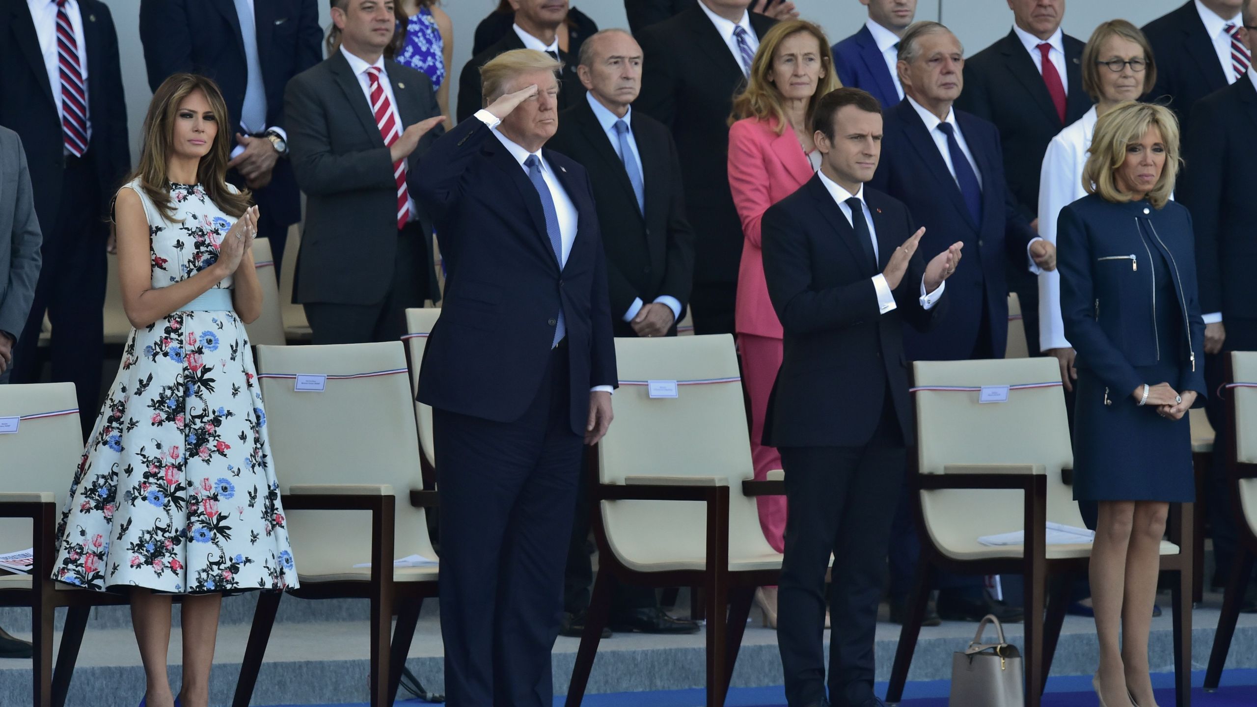 President Donald Trump salutes as French President Emmanuel Macron, his wife Brigitte Macron, and U.S. First Lady Melania Trump watch the annual Bastille Day military parade on the Champs-Elysees in Paris on July 14, 2017. (Credit: CHRISTOPHE ARCHAMBAULT/AFP/Getty Images)