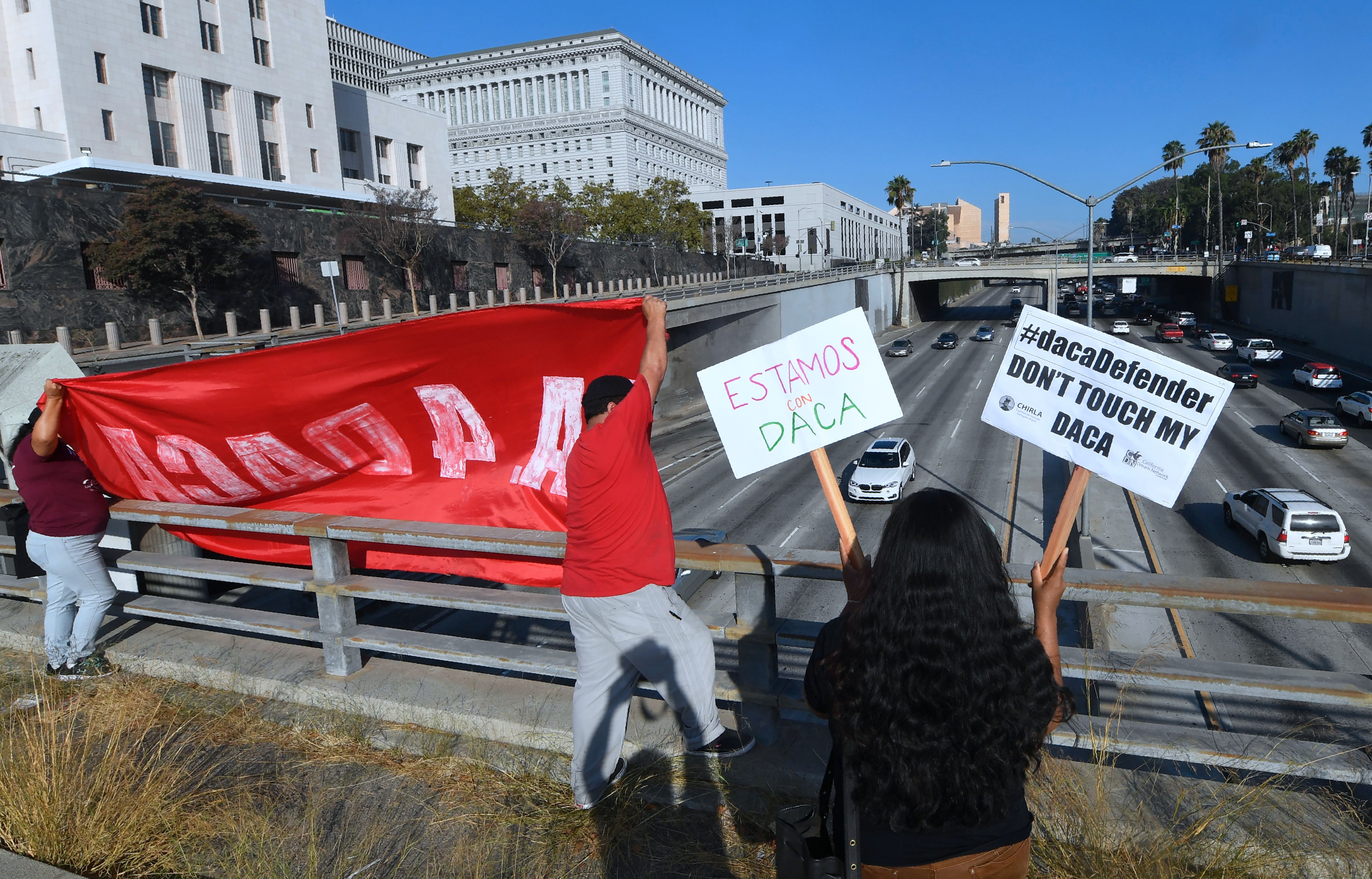 Volunteers from The Coalition for Humane Immigrant Rights (CHIRLA) protest with banners and placards over a freeway in Los Angeles on Aug. 28, 2017. (Credit: FREDERIC J. BROWN/AFP/Getty Images)