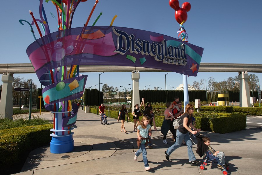 Pedestrians walk near the entrance to Disneyland Resort on Feb. 19, 2009 in Anaheim. (Credit: David McNew/Getty Images)